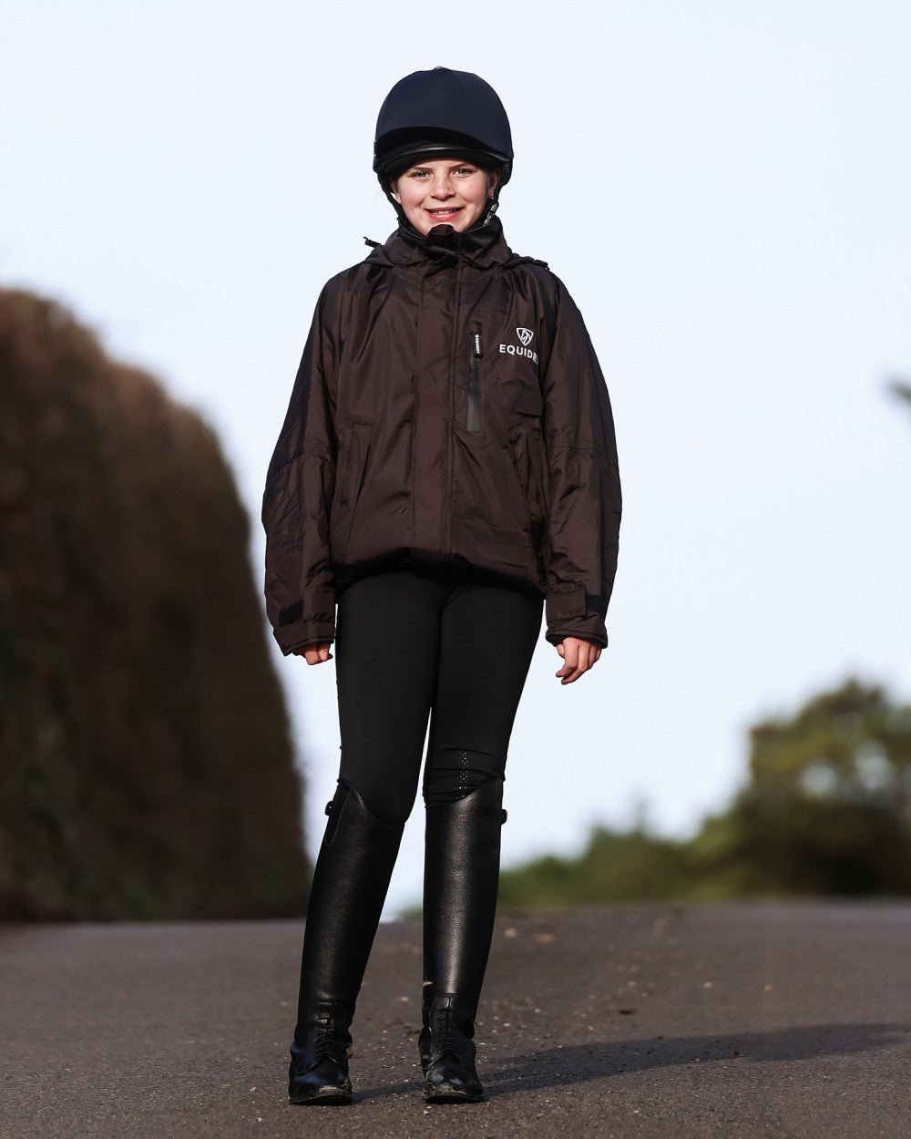 Rich Brown coloured Equidry Childrens Shortie Jacket on street background