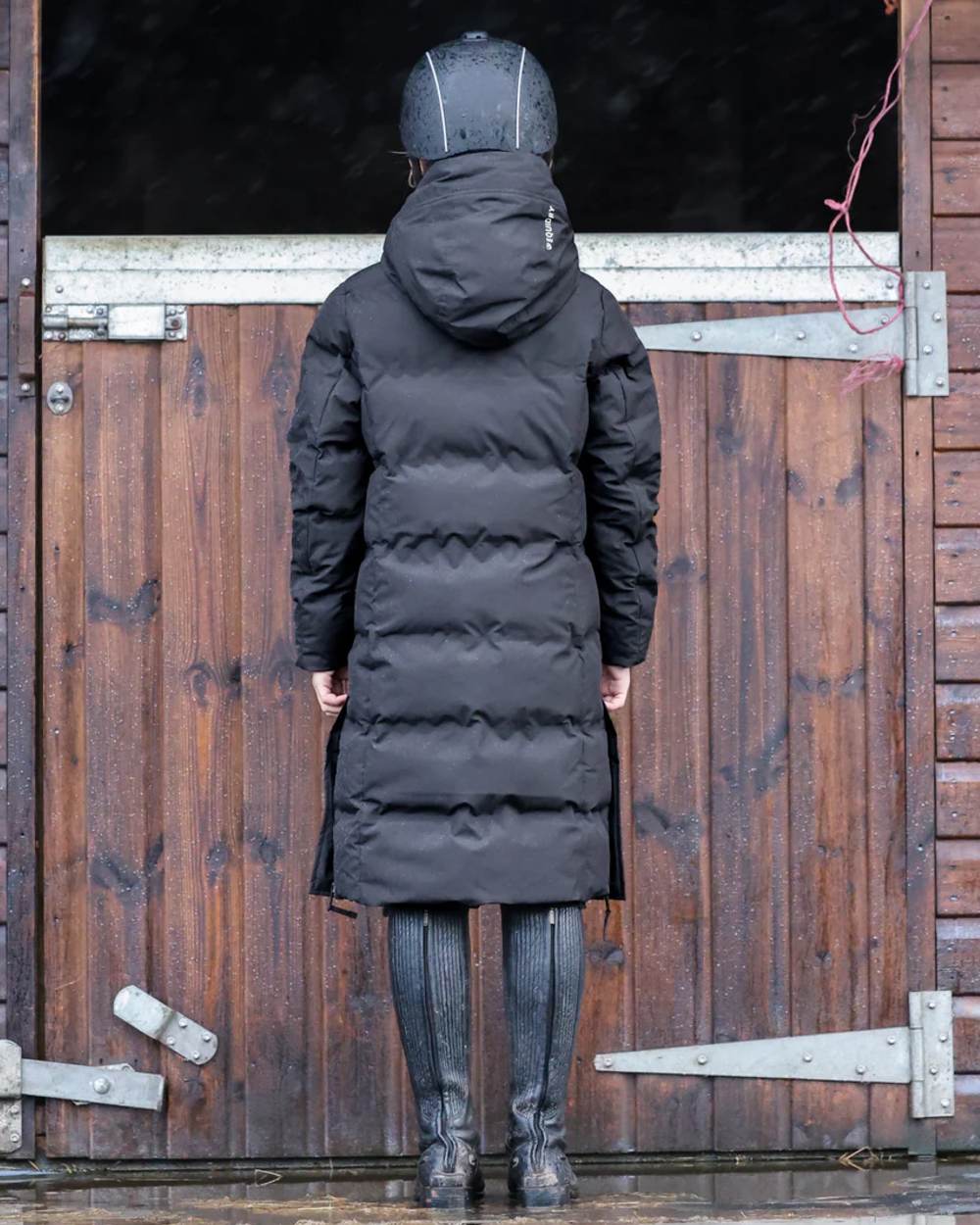 Black coloured Equidry Childrens Thora Waterproof Riding Puffer Jacket With Hood on stable background