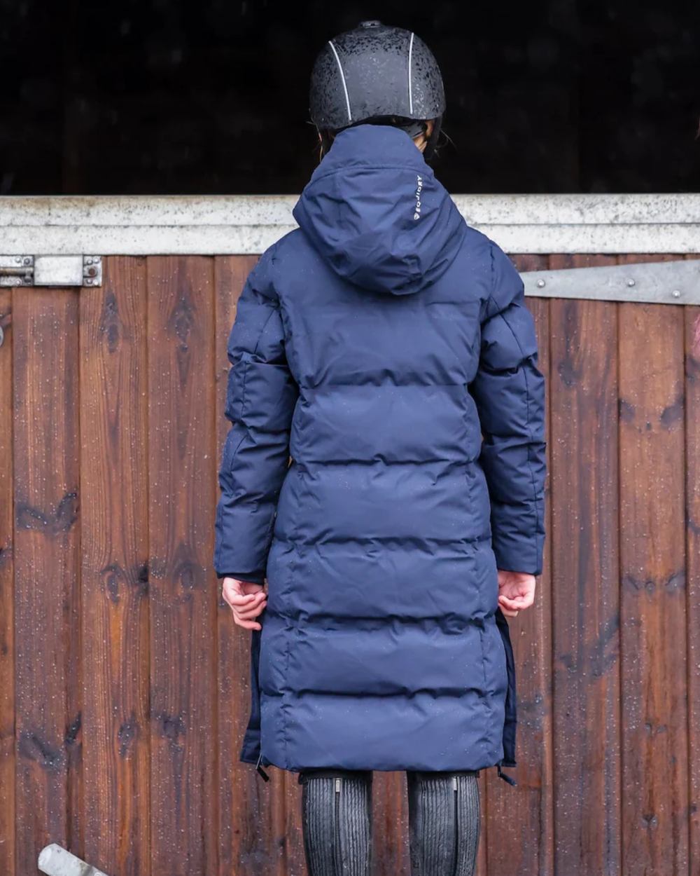 Navy coloured Equidry Childrens Thora Waterproof Riding Puffer Jacket With Hood on stable background