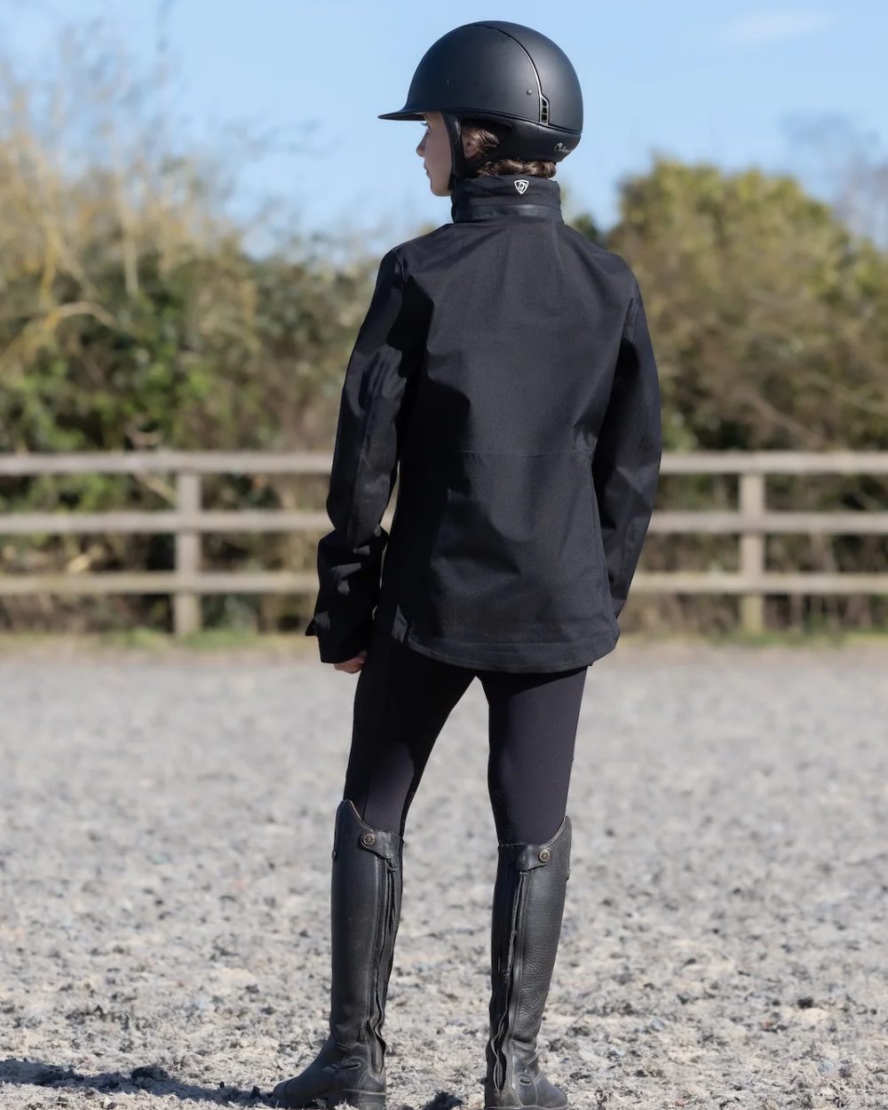 Black coloured Equidry Childrens Varsha Waterproof Jacket on farm background