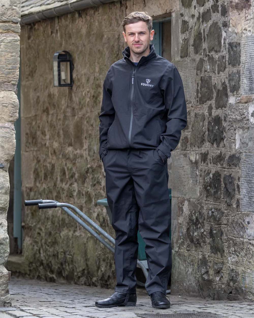 Black coloured Equidry Mens Nimbus Pack Away Jacket With Stowaway Hood on outdoor background