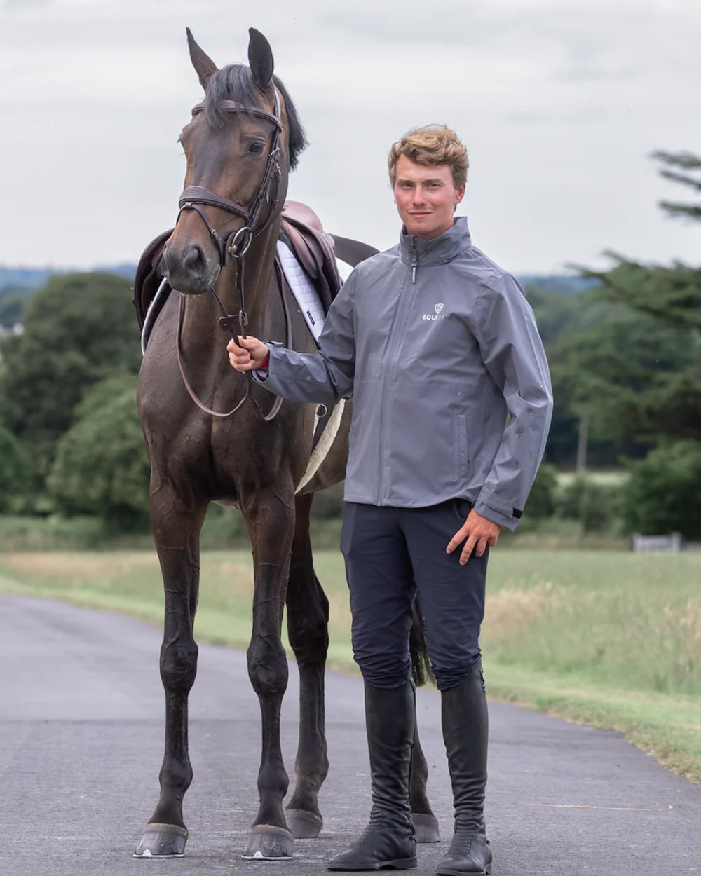 Charcoal coloured Equidry Mens Nimbus Pack Away Jacket With Stowaway Hood on outdoor background