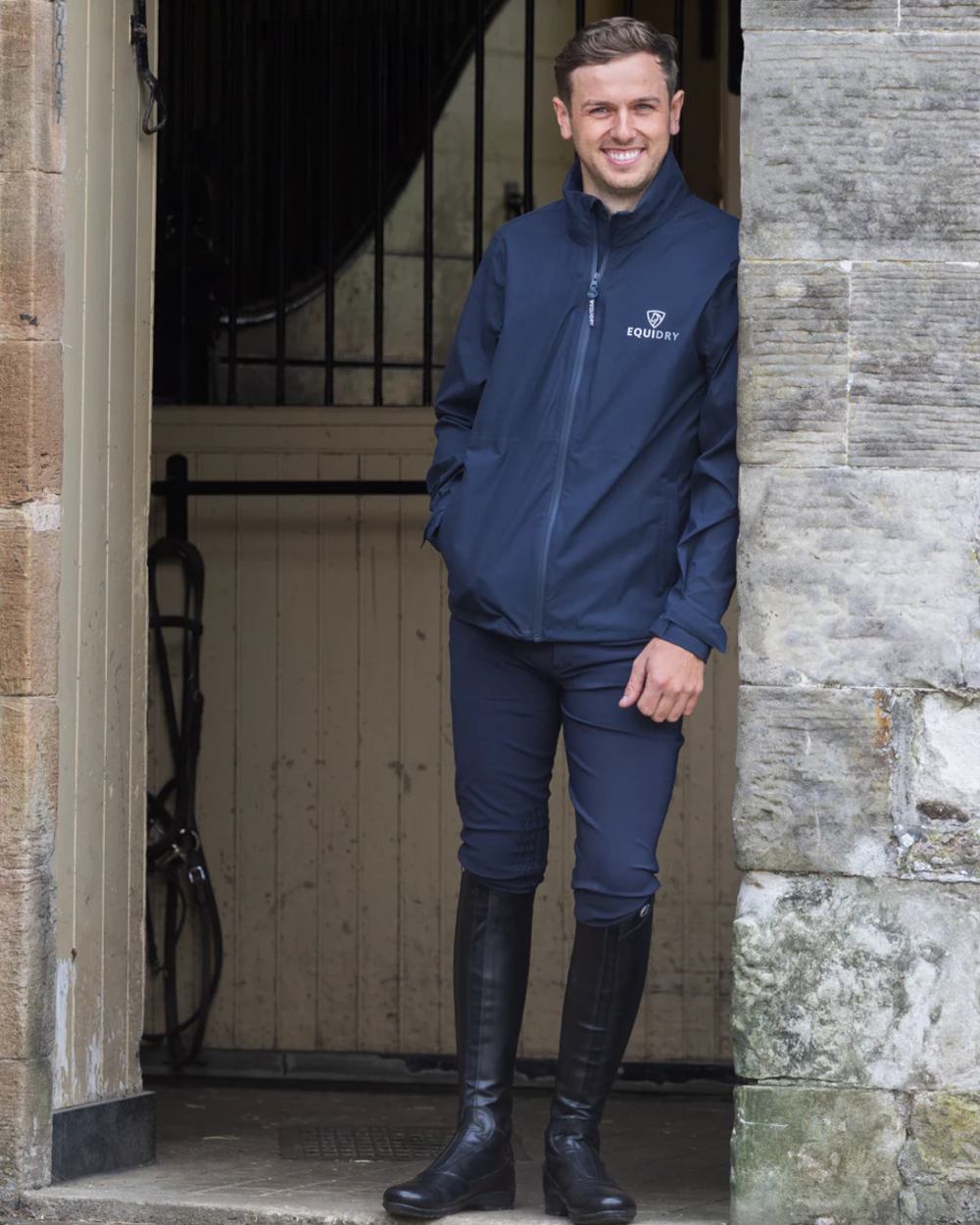 Navy coloured Equidry Mens Nimbus Pack Away Jacket With Stowaway Hood on outdoor background