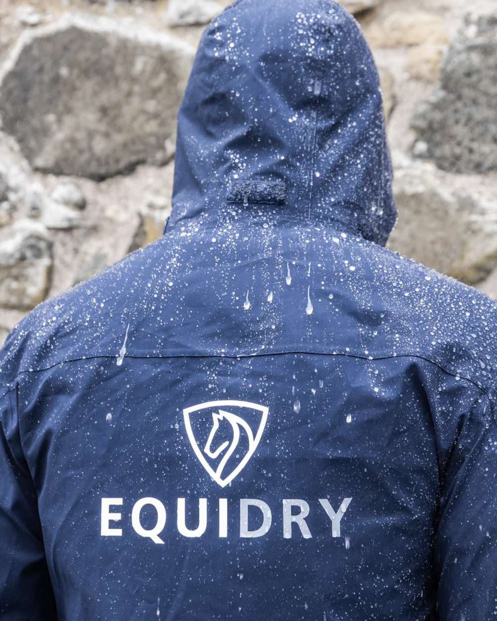 Navy coloured Equidry Mens Nimbus Pack Away Jacket With Stowaway Hood on outdoor background