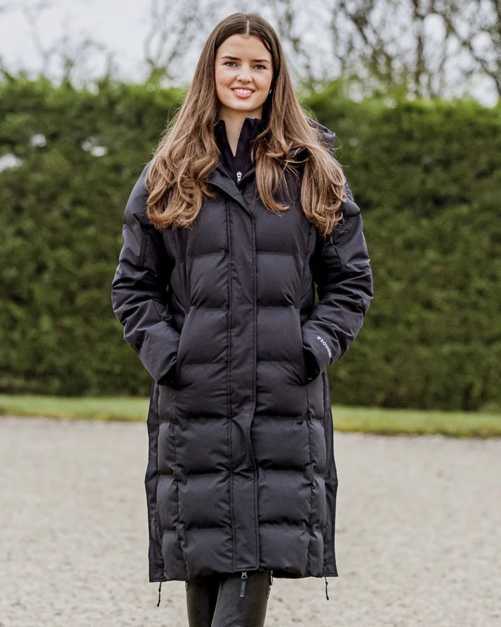Black coloured Equidry Thora Waterproof Riding Puffer Coat With Hood on outdoor background