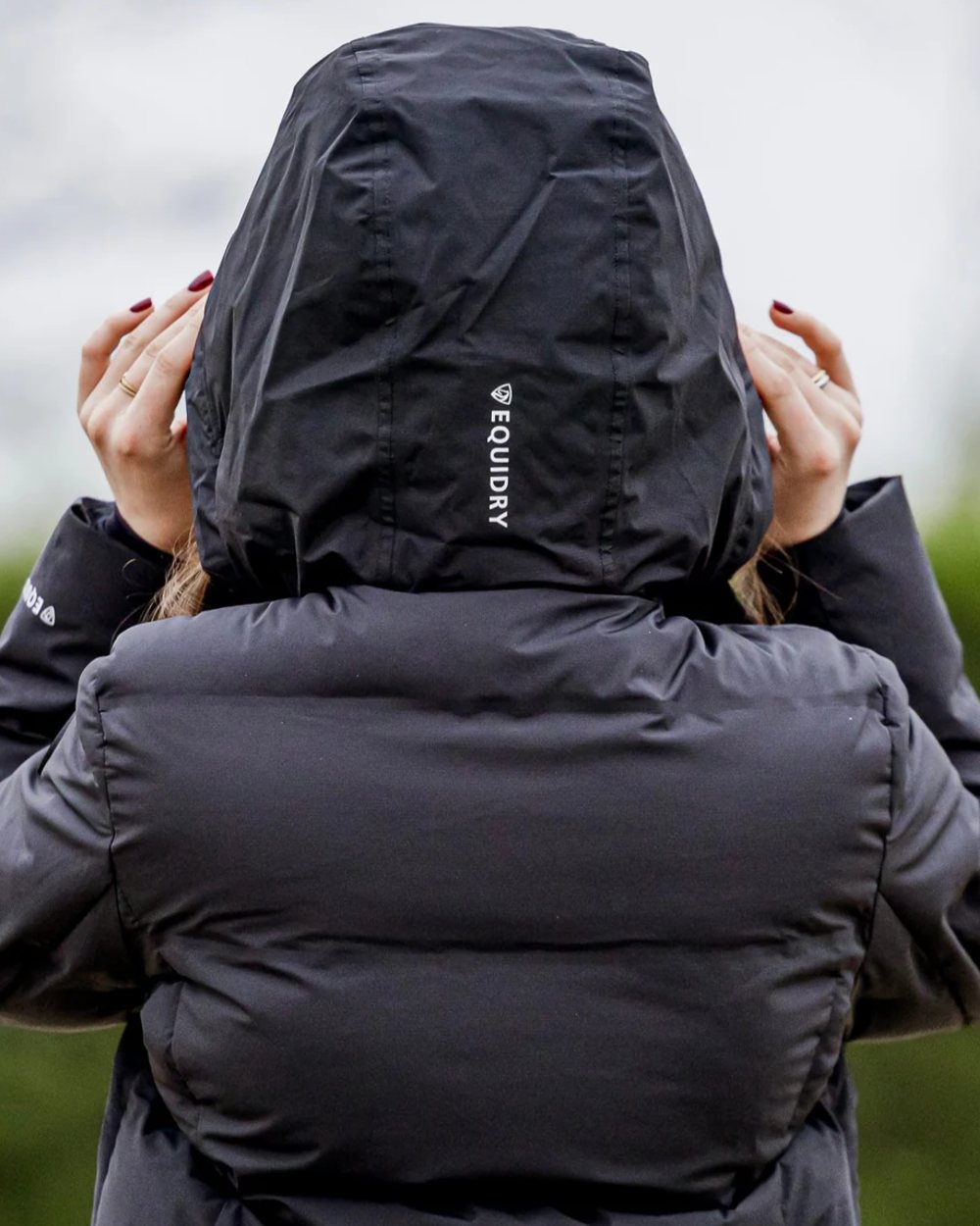 Black coloured Equidry Thora Waterproof Riding Puffer Coat With Hood on outdoor background