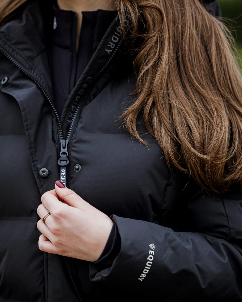 Black coloured Equidry Thora Waterproof Riding Puffer Coat With Hood on outdoor background