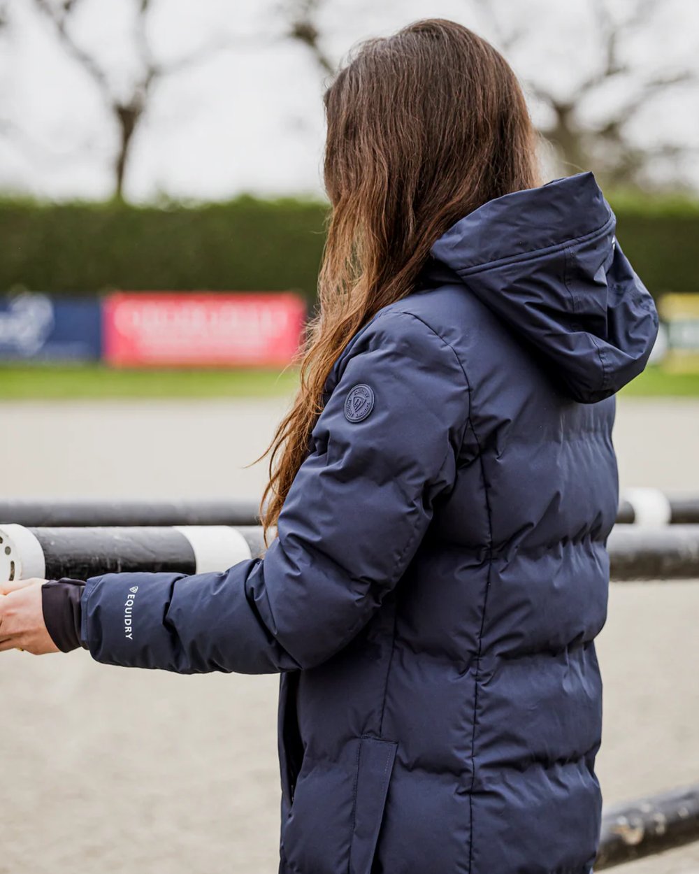 Navy coloured Equidry Thora Waterproof Riding Puffer Coat With Hood on outdoor background