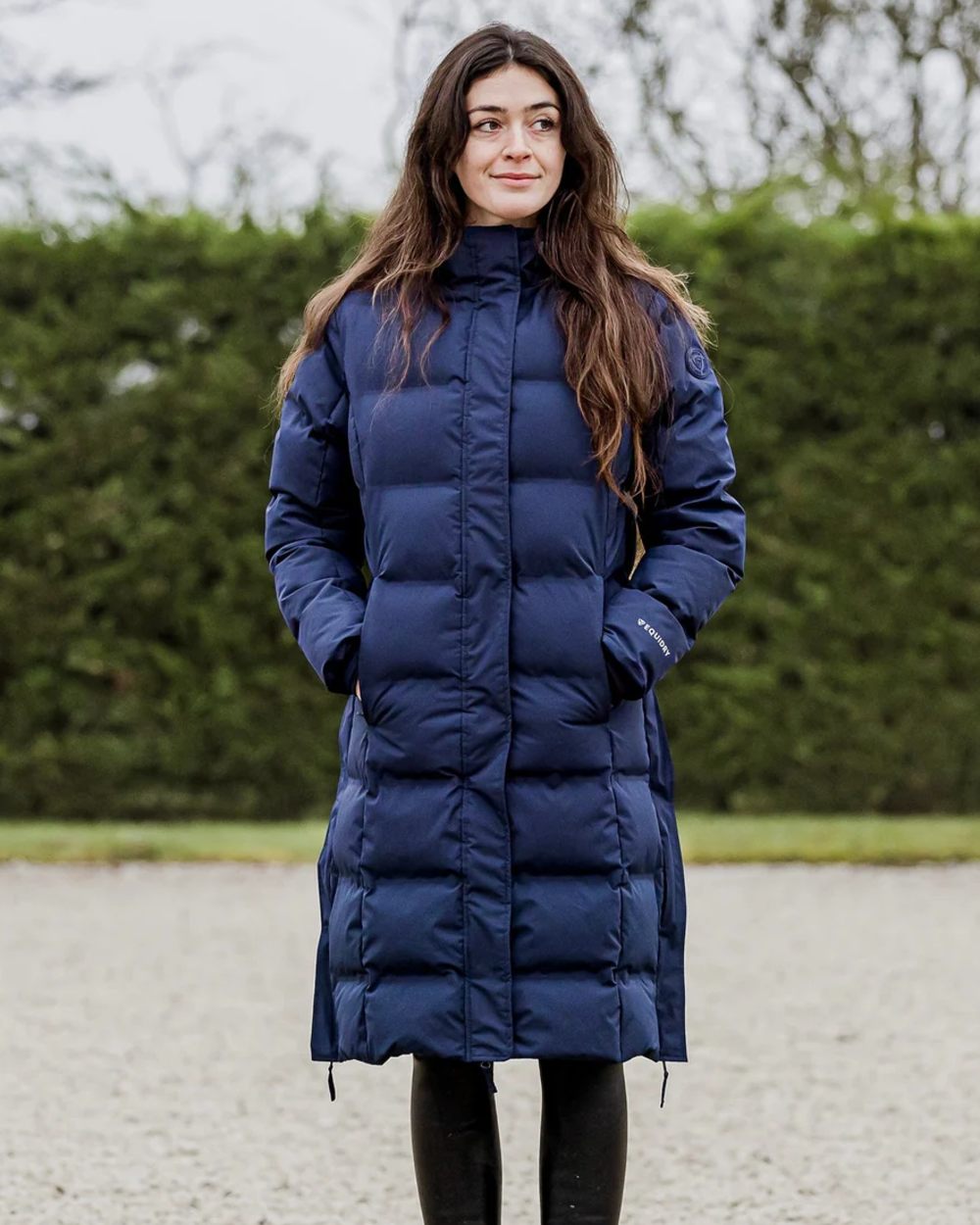 Navy coloured Equidry Thora Waterproof Riding Puffer Coat With Hood on outdoor background