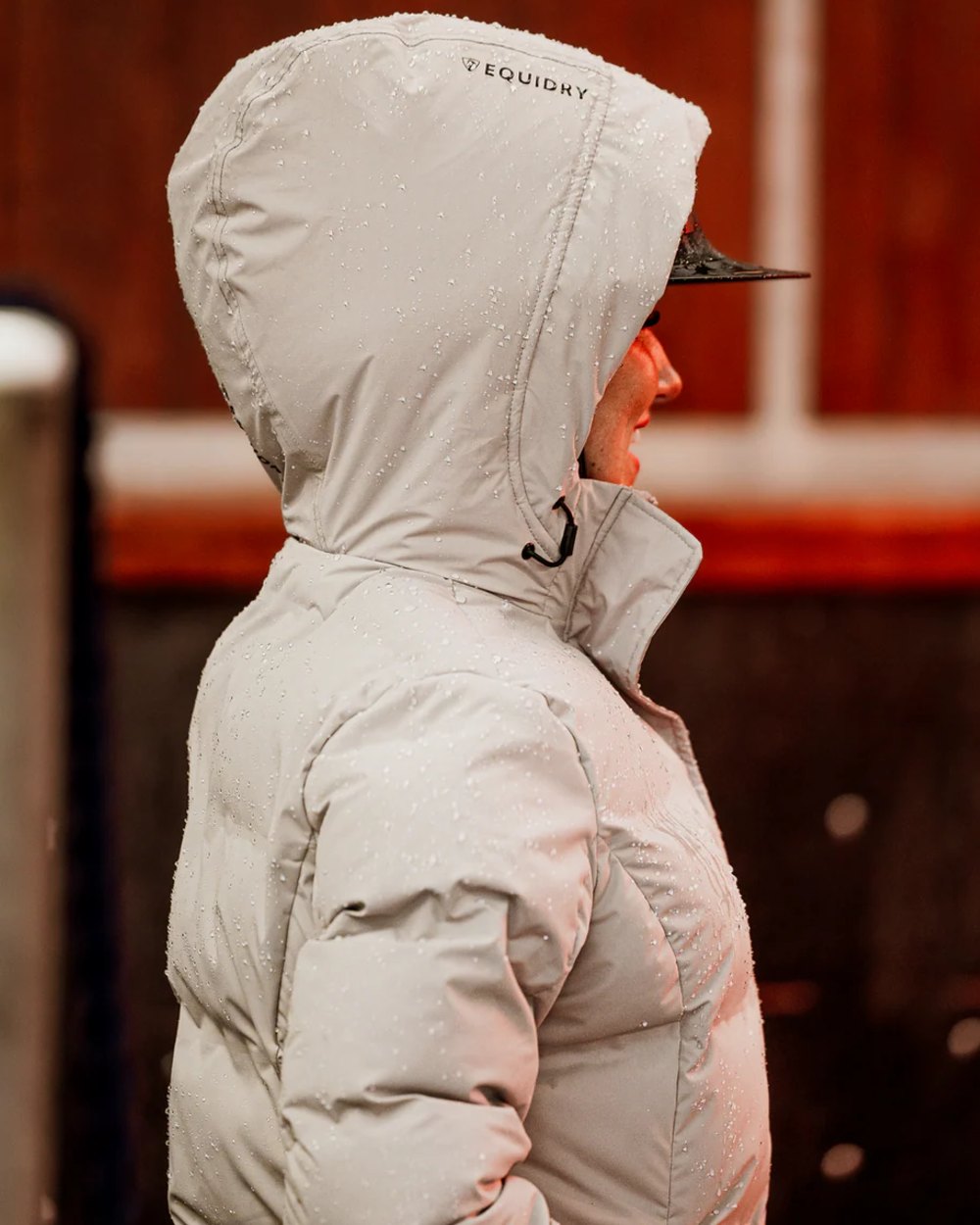 Taupe coloured Equidry Thora Waterproof Riding Puffer Coat With Hood on outdoor background
