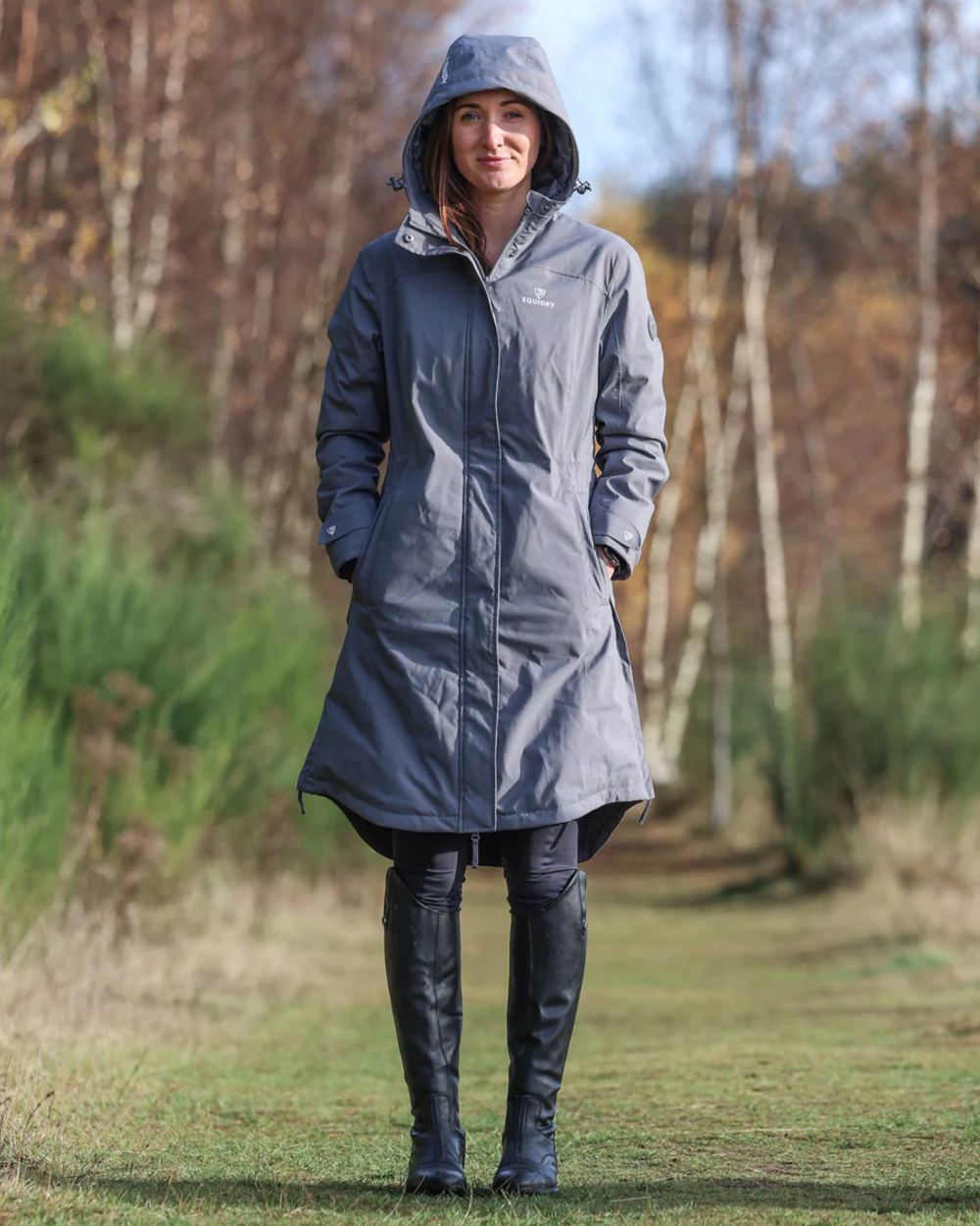 Charcoal coloured Equidry Womens Bronte Riding Coat on forest background