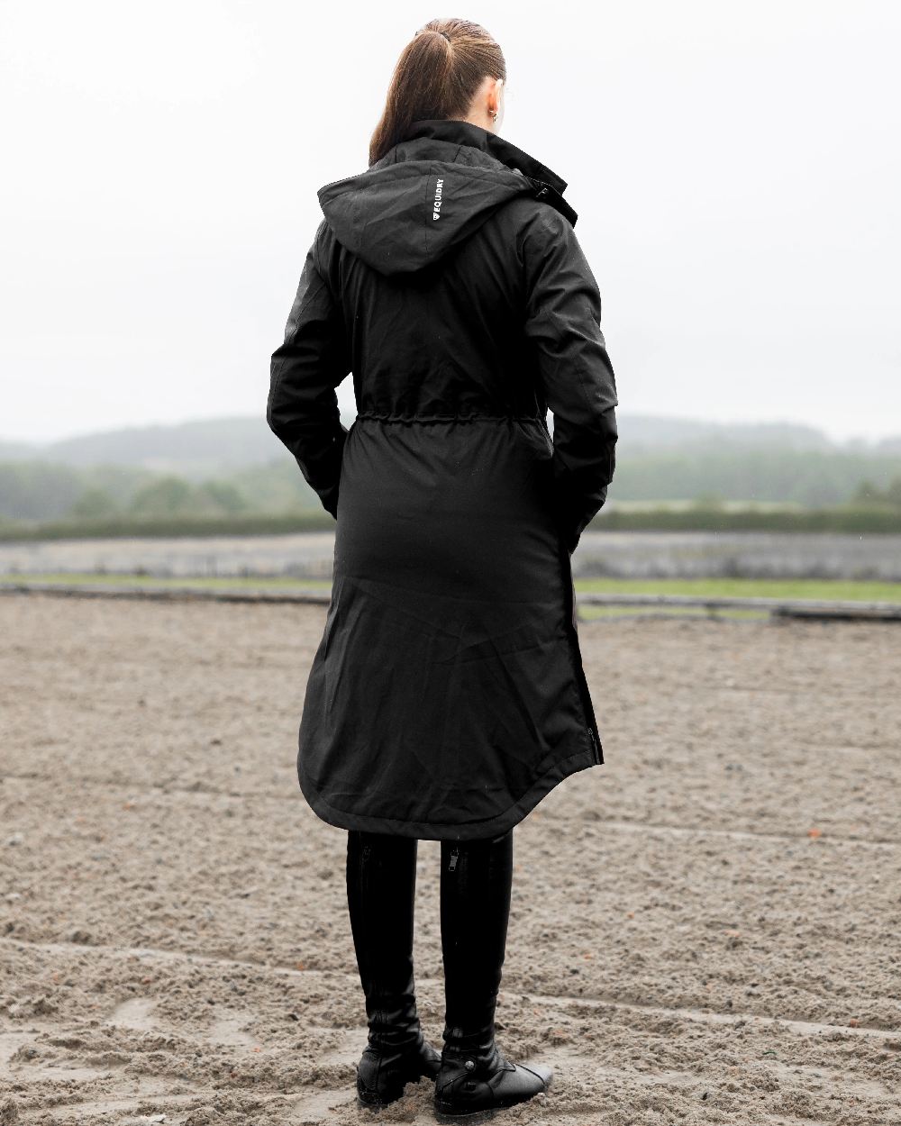 Black Coloured Equidry Womens Bronte Riding Coat With Removable Hood on outdoor background
