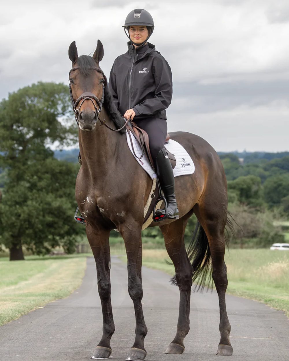 Black coloured Equidry Womens Nimbus Pack Away Jacket with Stowaway Hood on street background