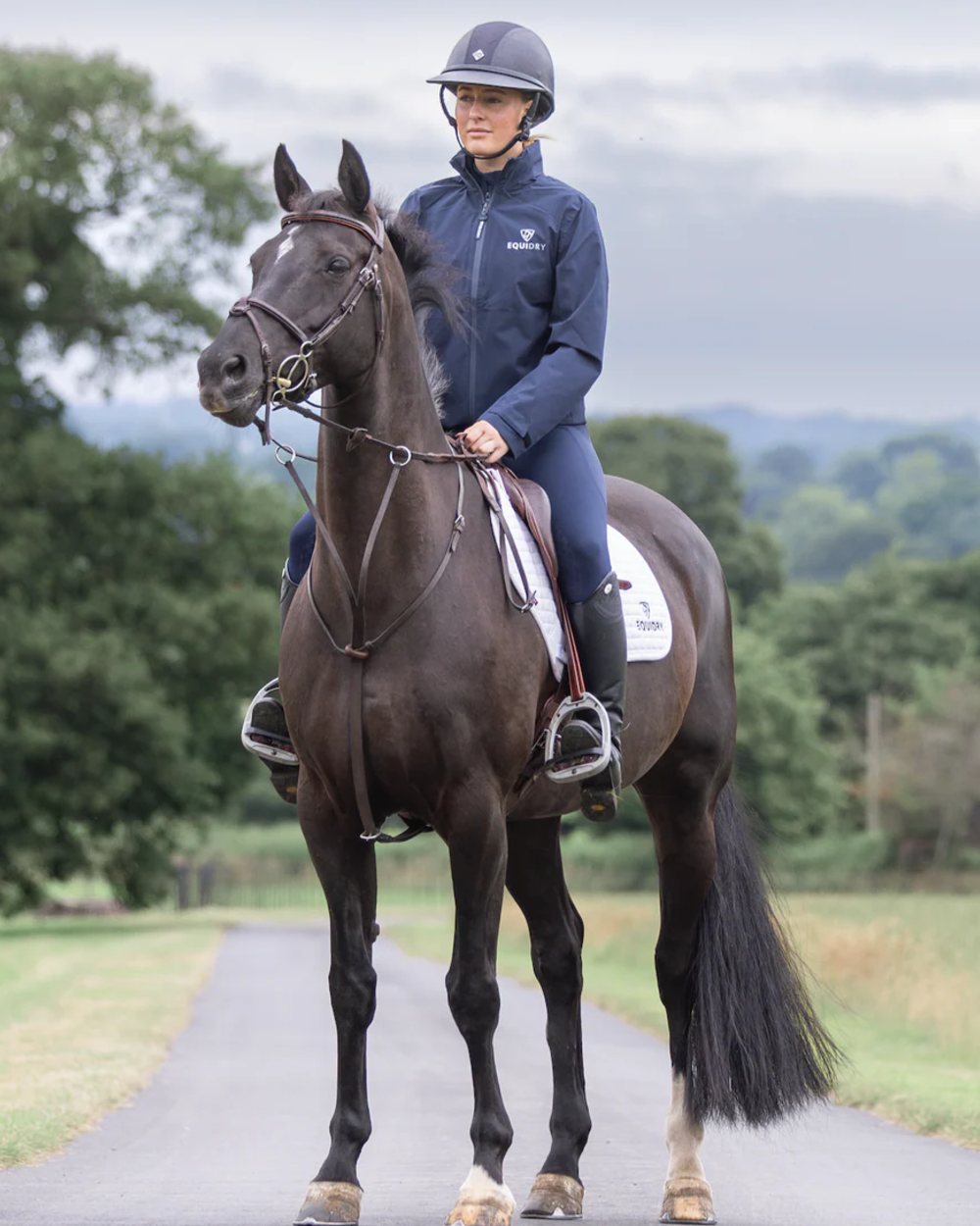 Navy coloured Equidry Womens Nimbus Pack Away Jacket with Stowaway Hood on street background