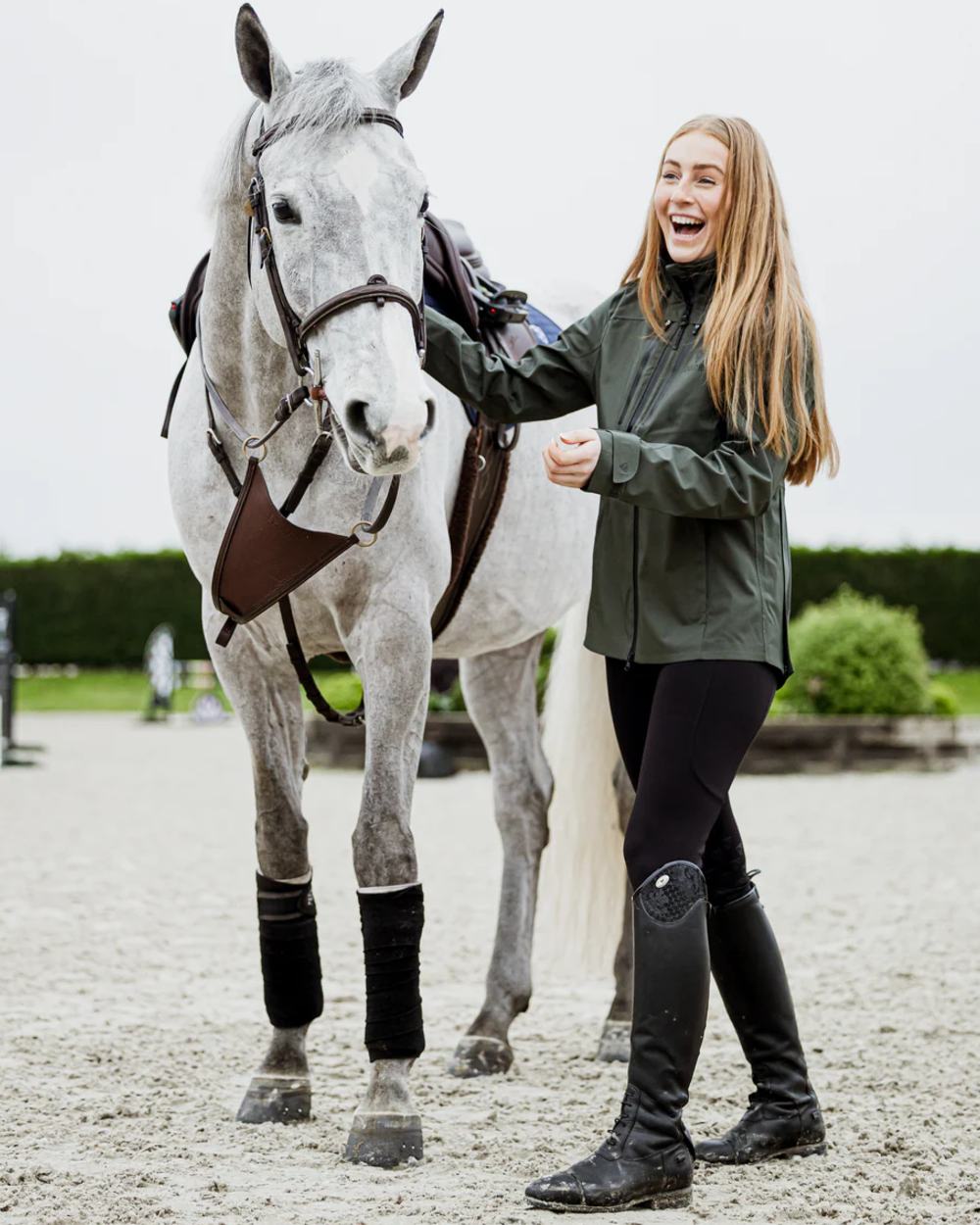 Khaki coloured Equidry Womens Varsha Jacket with Stowaway Hood on street background