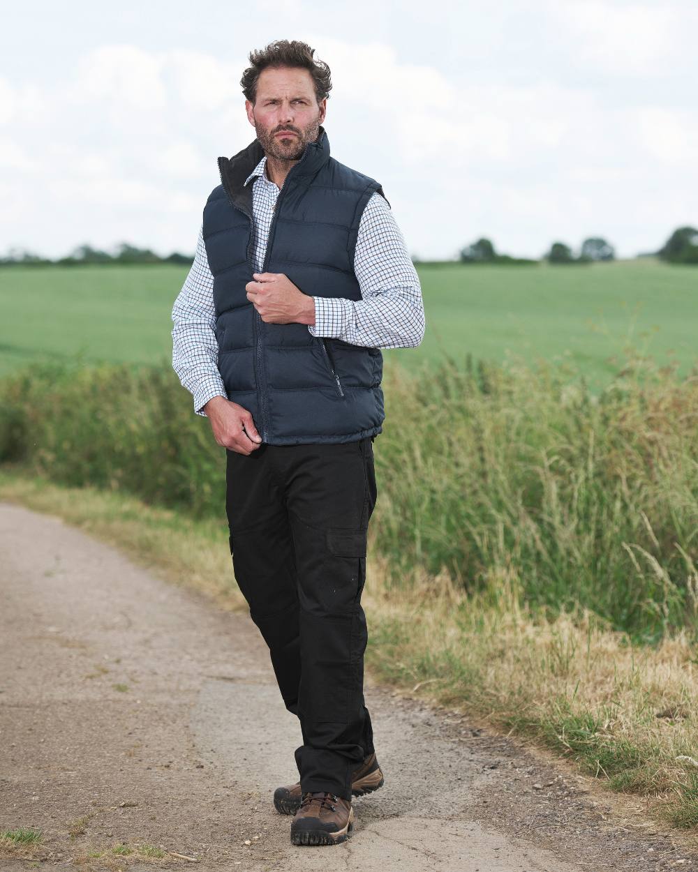Navy coloured Fort Downham Bodywarmer on blurry green background