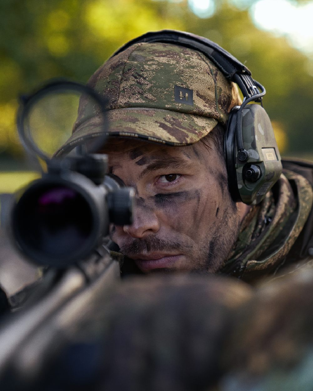 AXIS Forest Coloured Harkila Deer Stalker Camo HWS Cap on blurry background