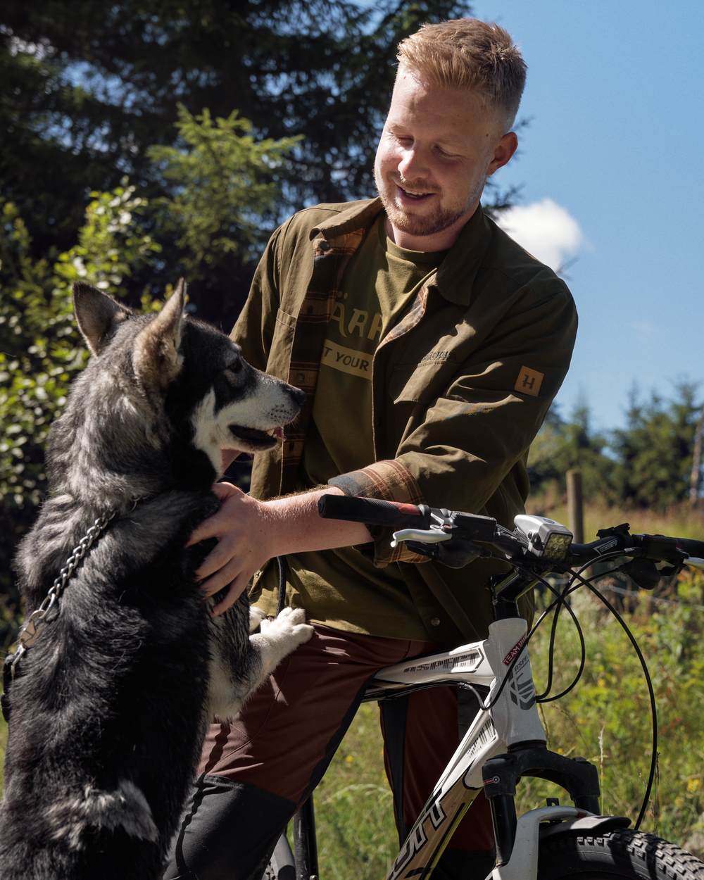 Dark Warm Olive Burgundy Coloured Harkila Eirik Reversible Shirt Jacket on countryside background