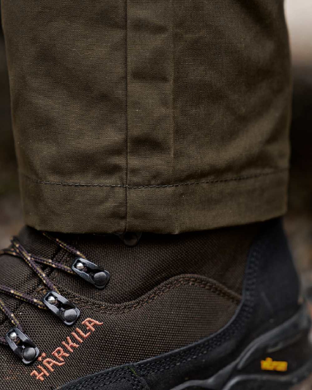 Willow Green Shadow Brown Coloured Harkila Fjell Trousers on blurry background