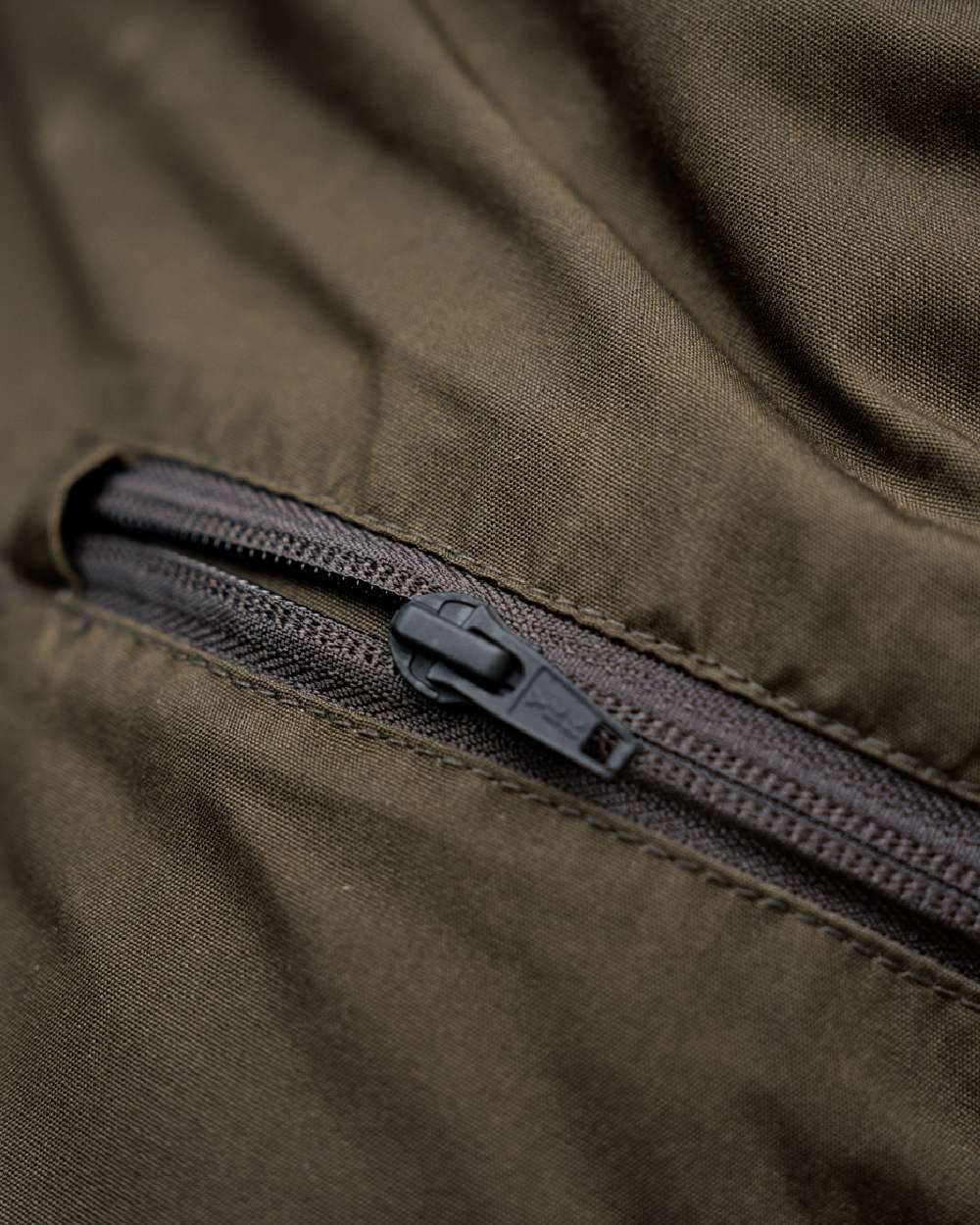 Willow Green Shadow Brown Coloured Harkila Fjell Trousers on blurry background