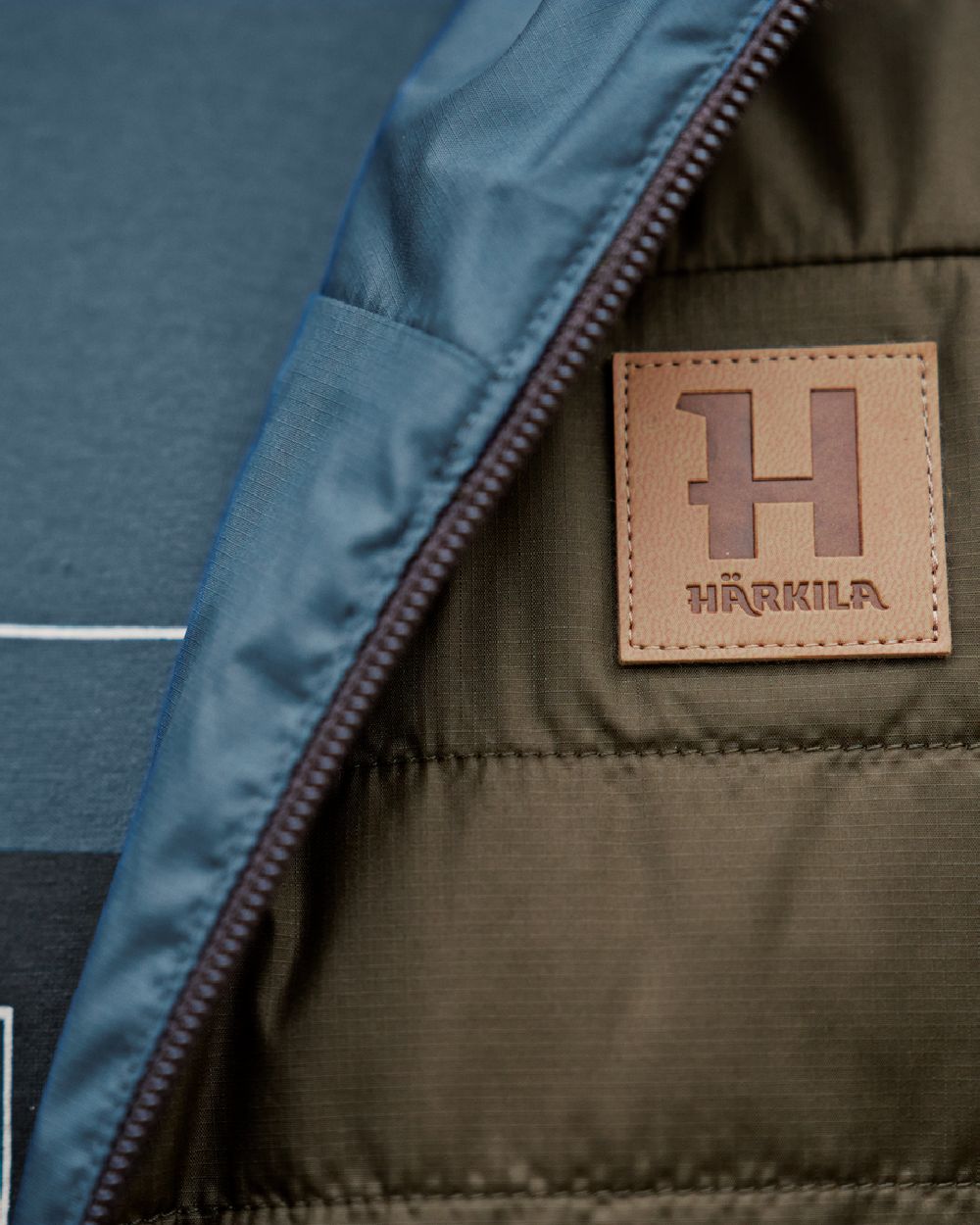 Willow Green Sea Blue Coloured Harkila Mens Kalix HSP Jacket on blurry background