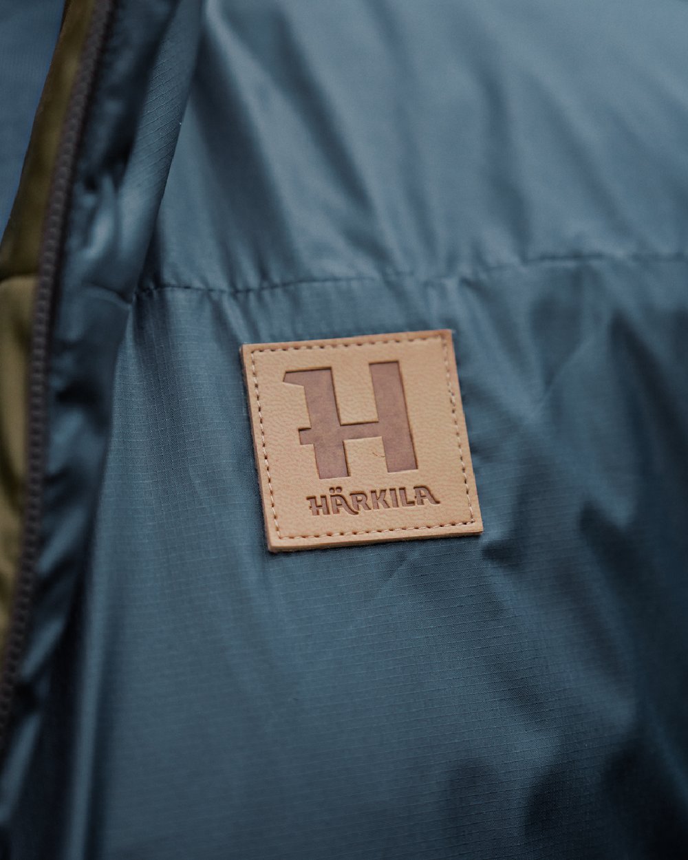 Willow Green Sea Blue Coloured Harkila Mens Kalix HSP Jacket on blurry background