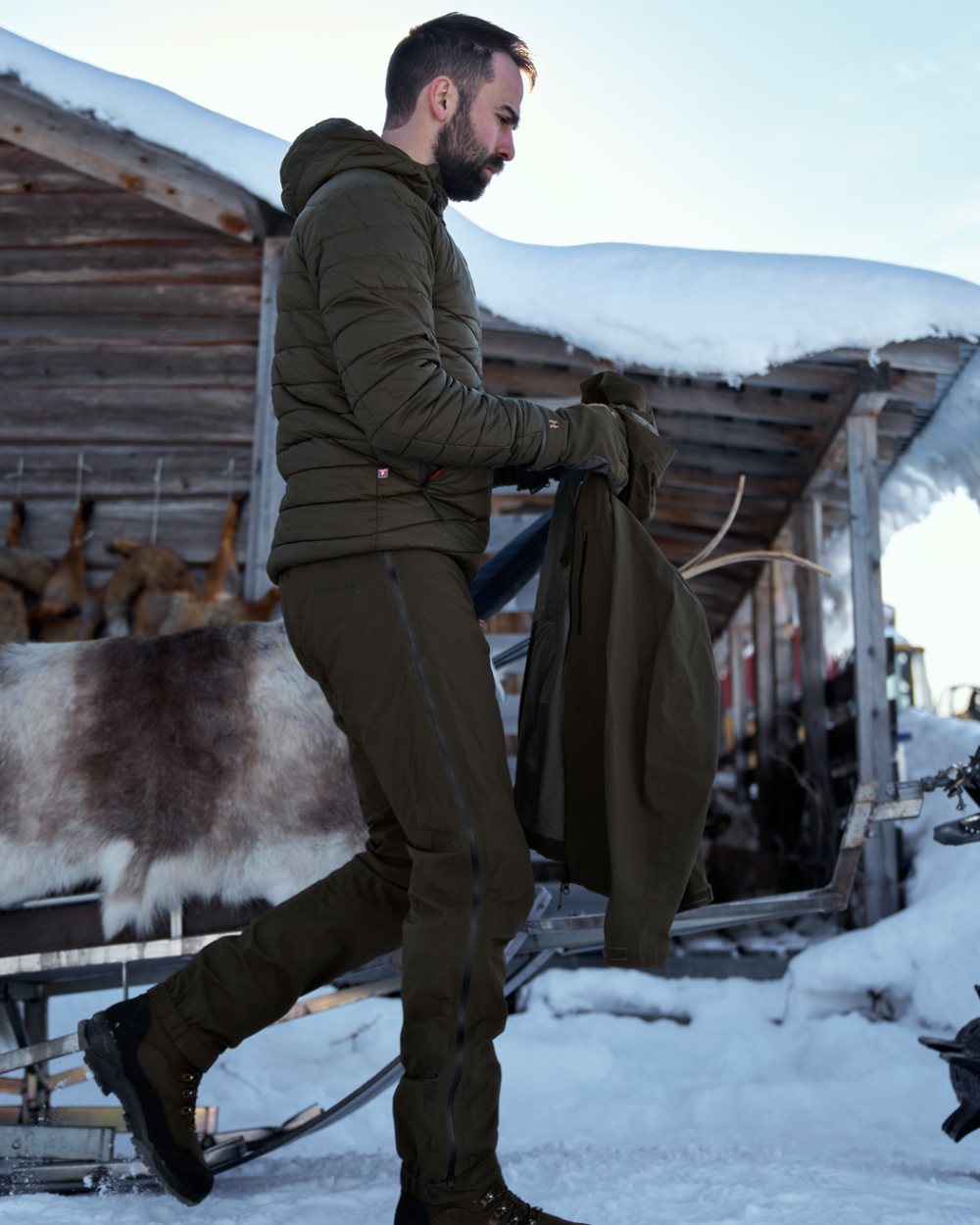 Willow Green coloured Harkila Mens Logmar HWS Packable Trousers on snow background