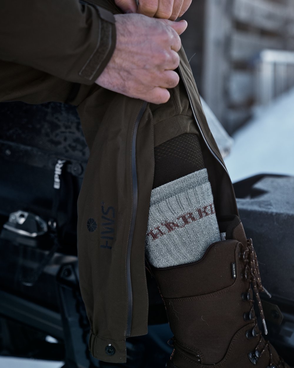 Willow Green coloured Harkila Mens Logmar HWS Packable Trousers on snow background