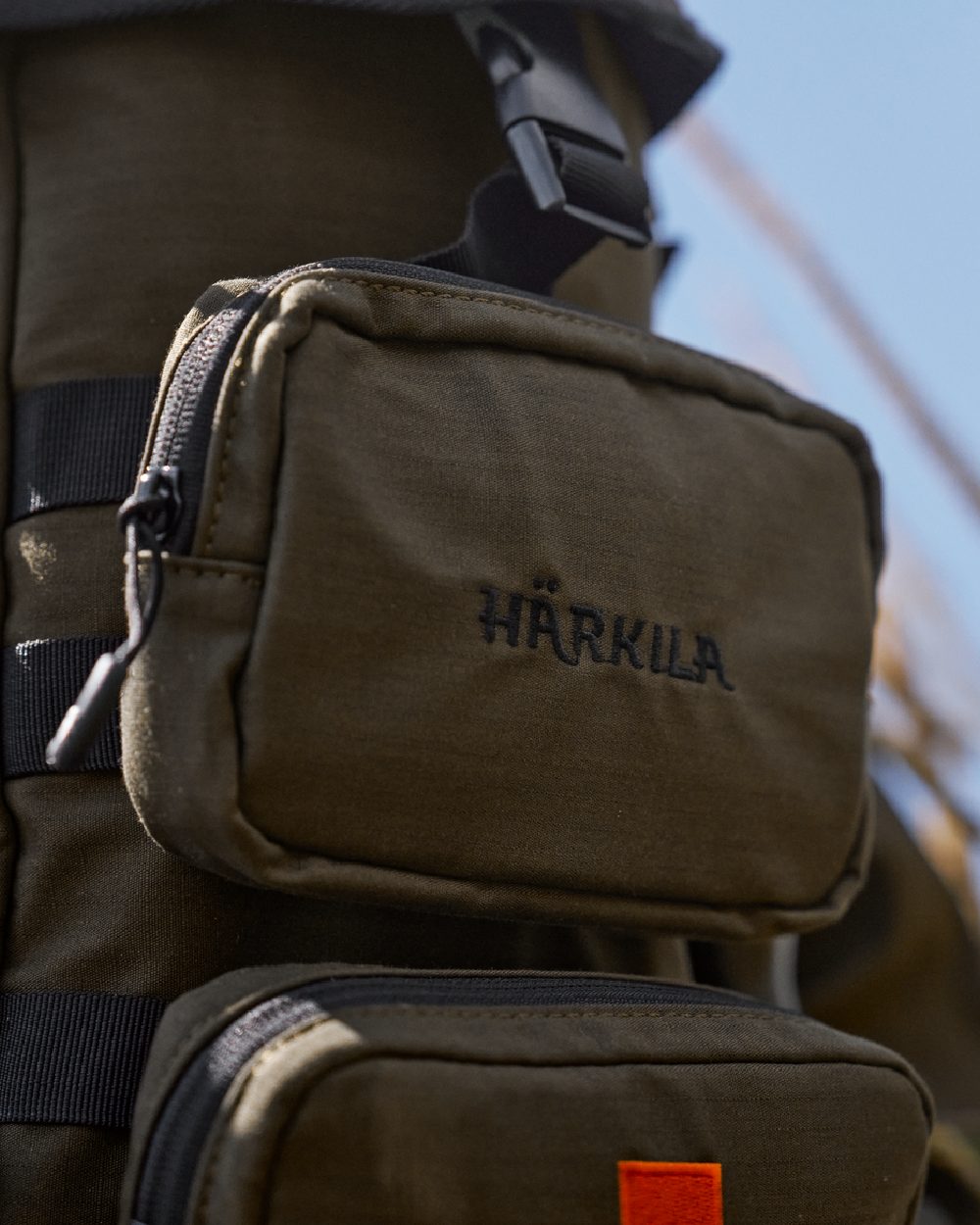 Willow Green Coloured Harkila Ragnar First Aid Backpack on blurry background