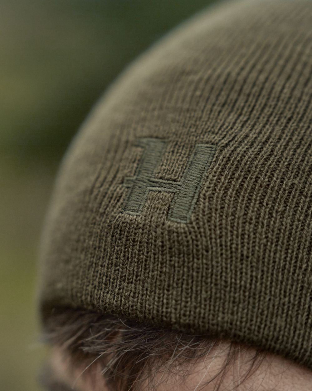 Willow Green Orange Coloured Harkila Reversible Beanie on outdoor background