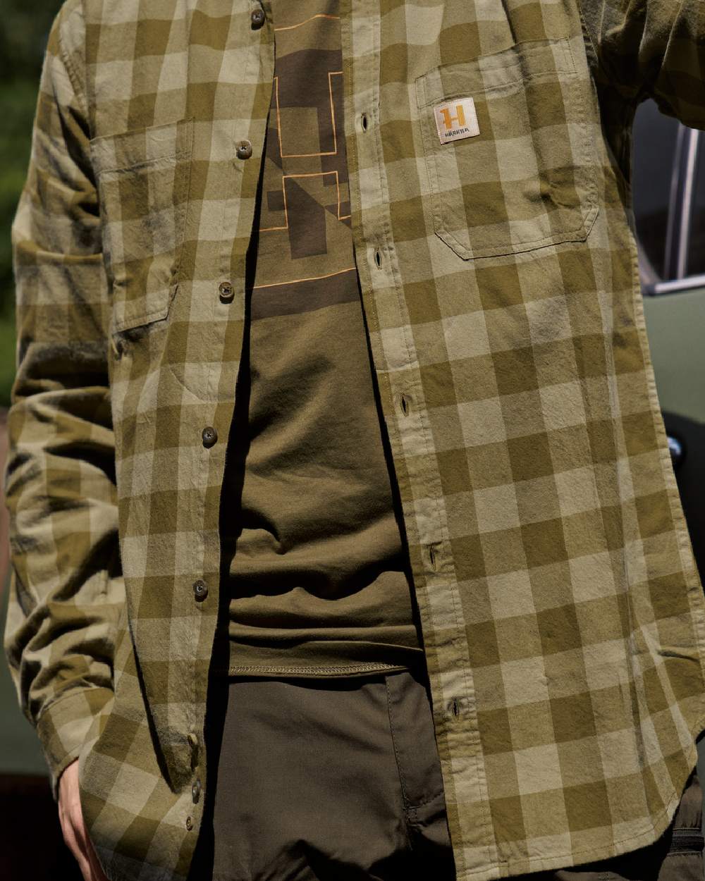 Dark Olive Check Coloured Harkila Scandinavian Long Sleeve Shirt on blurry background