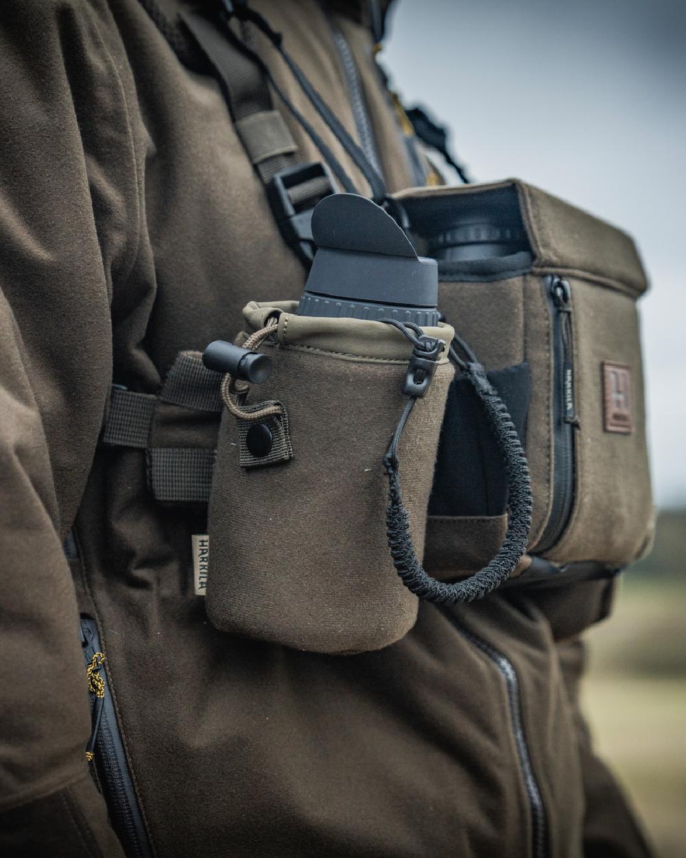 Dark Willow Green Coloured Harkila Thermal Spotter Pouch on blurry background