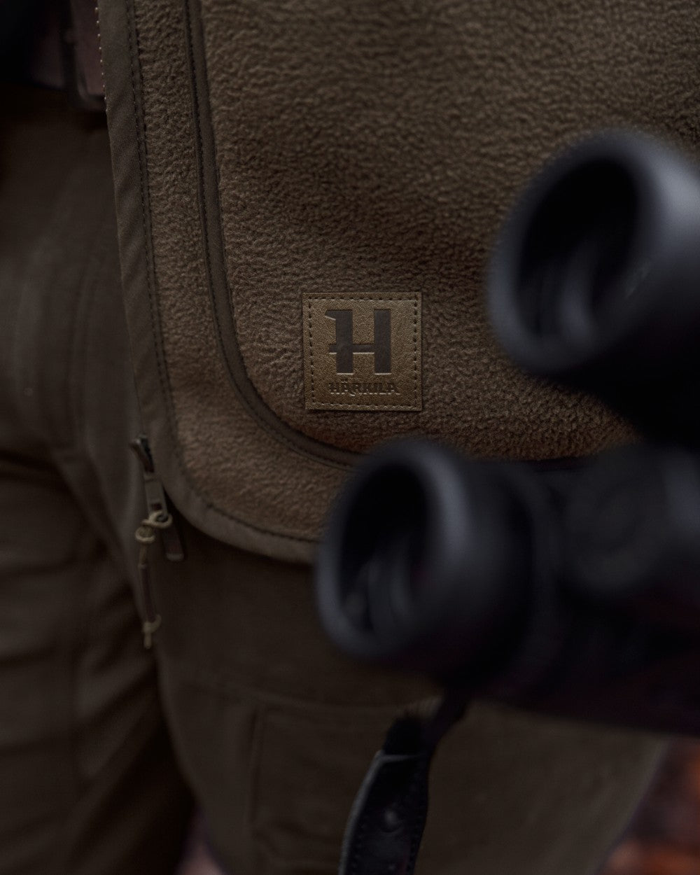 Dark Brown coloured Harkila Torsby Fleece Jacket on outdoor background