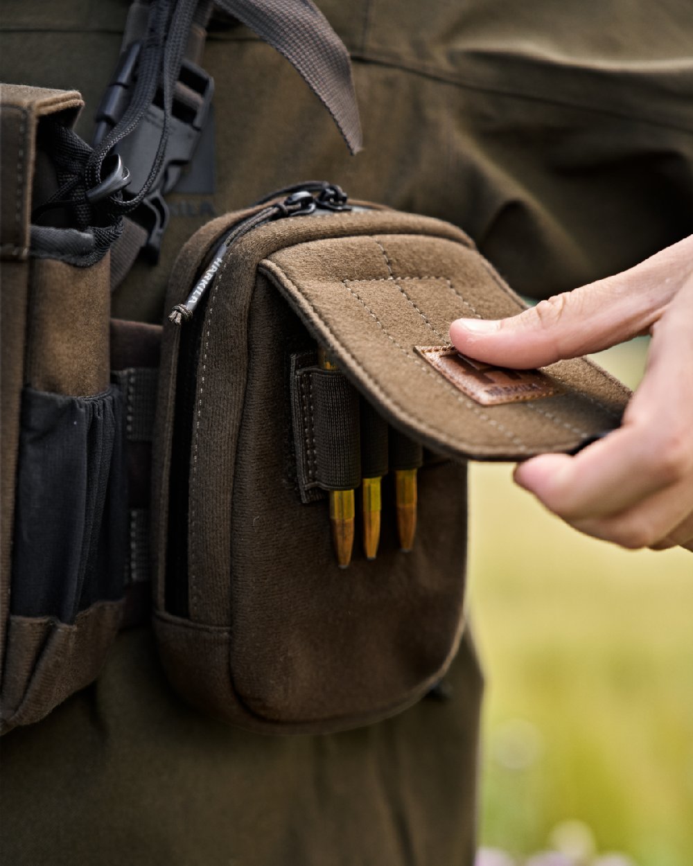 Dark Willow Green Coloured Harkila Utility Pouch on blurry background