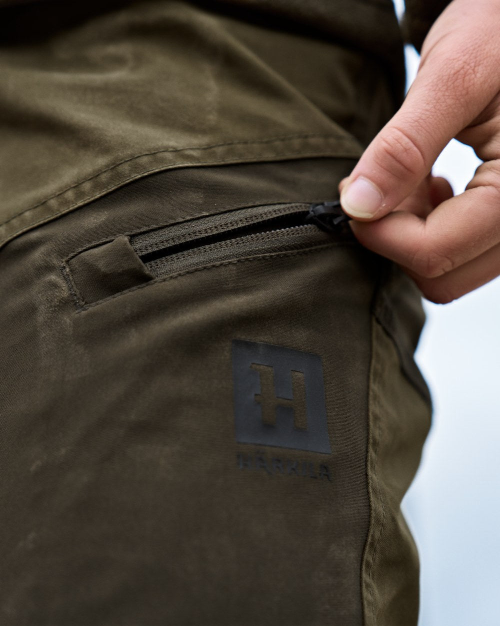 Dark Olive Willow Green Coloured Harkila Womens Fjell Trousers on blurry background