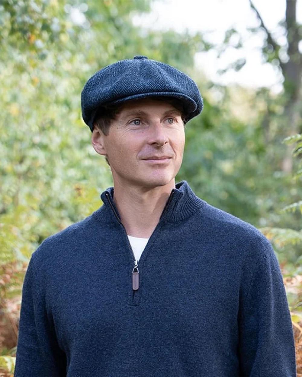 Midnight coloured Heather Brodick Harris Tweed 8-Piece Cap on forest background