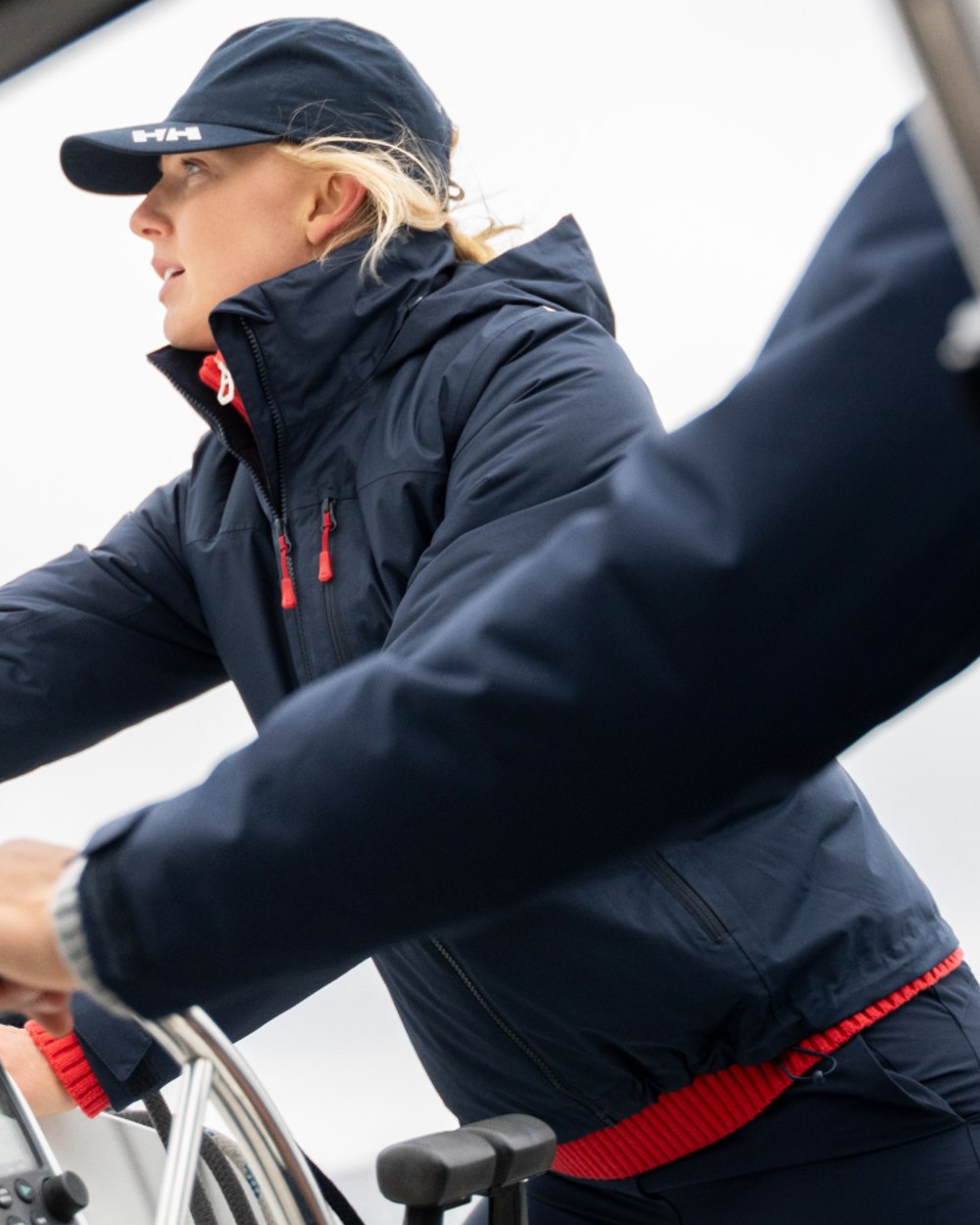 Navy coloured Helly Hansen Mens Crew Hooded Midlayer Jacket on sea background