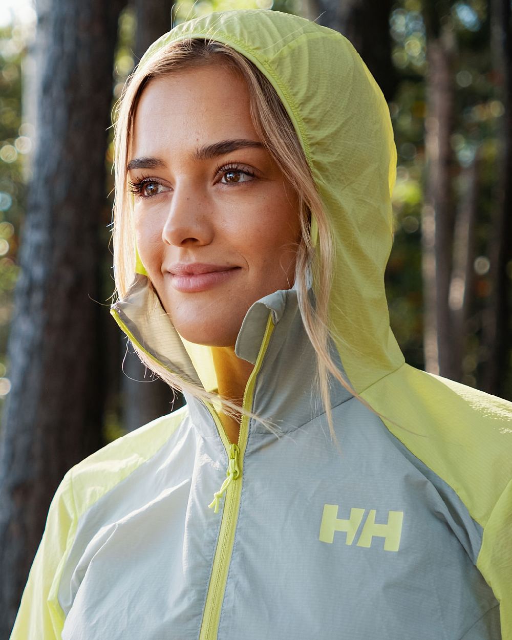 Sharp Green coloured Helly Hansen Womens Roam Wind Anorak on blurry background