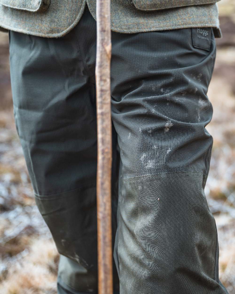 Green Coloured Hoggs of Fife Green King II Waterproof Trousers on blurry background