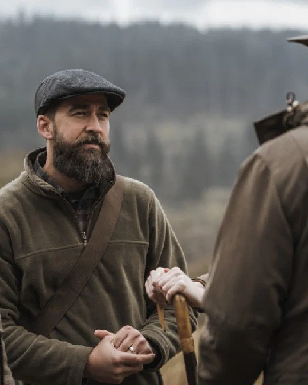 Green Coloured Hoggs of Fife Herringbone Waterproof Tweed Flat Cap on forest background