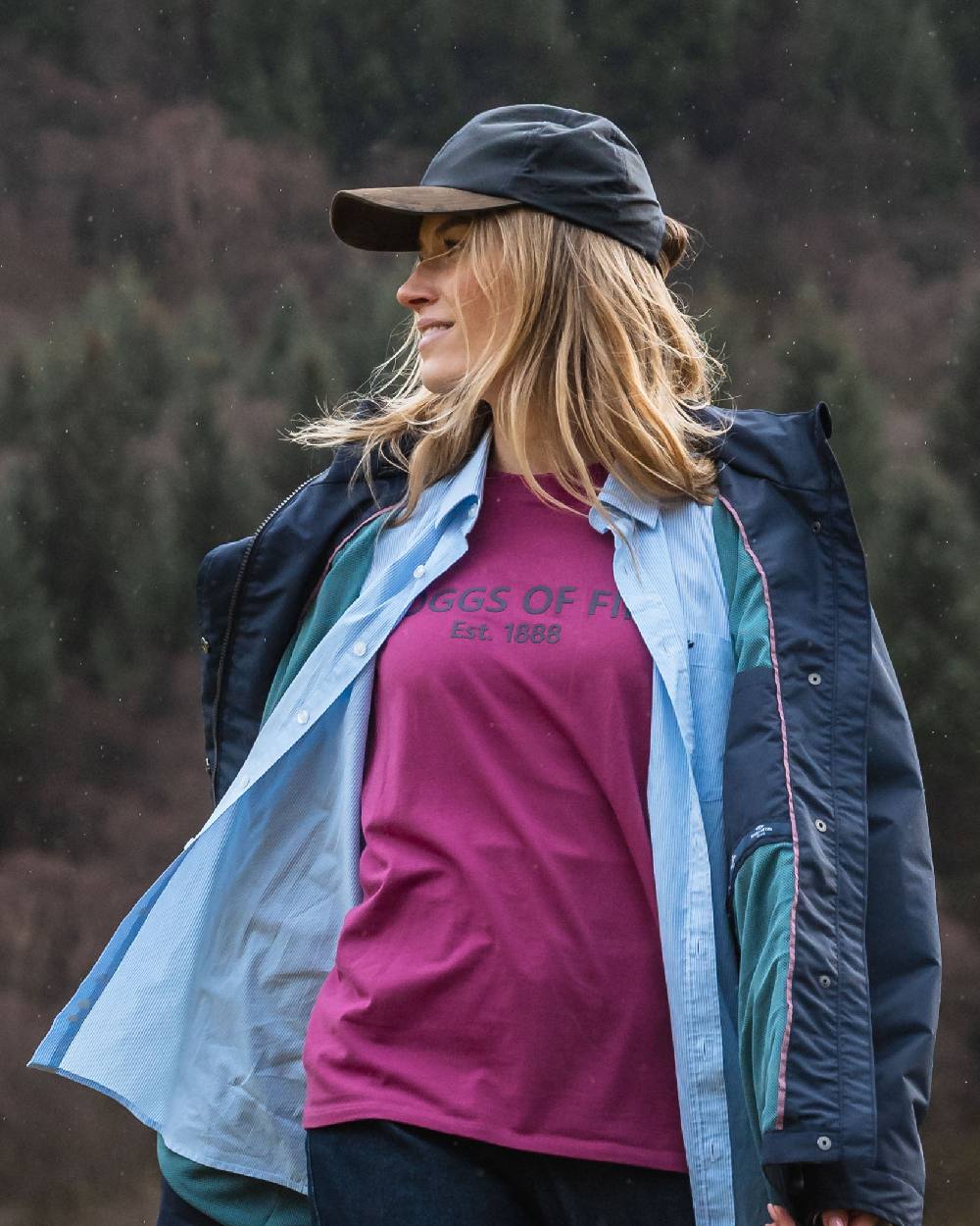 Navy Coloured Hoggs of Fife Leather Peak Waxed Baseball Cap on blurry background