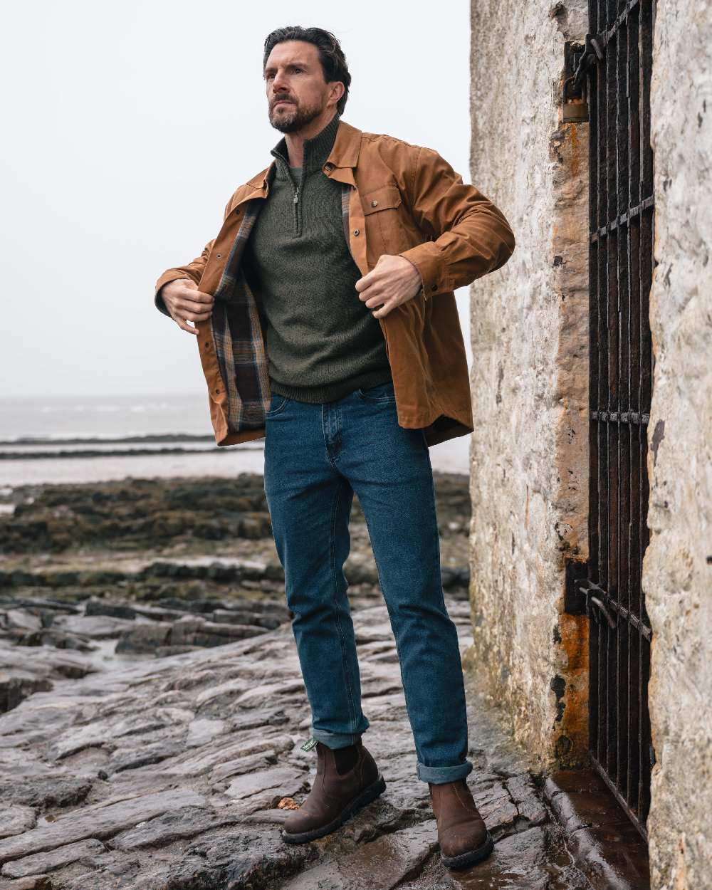 Caramel coloured Hoggs of Fife Mens Huntly Waxed Canvas Utility Overshirt on coastal background