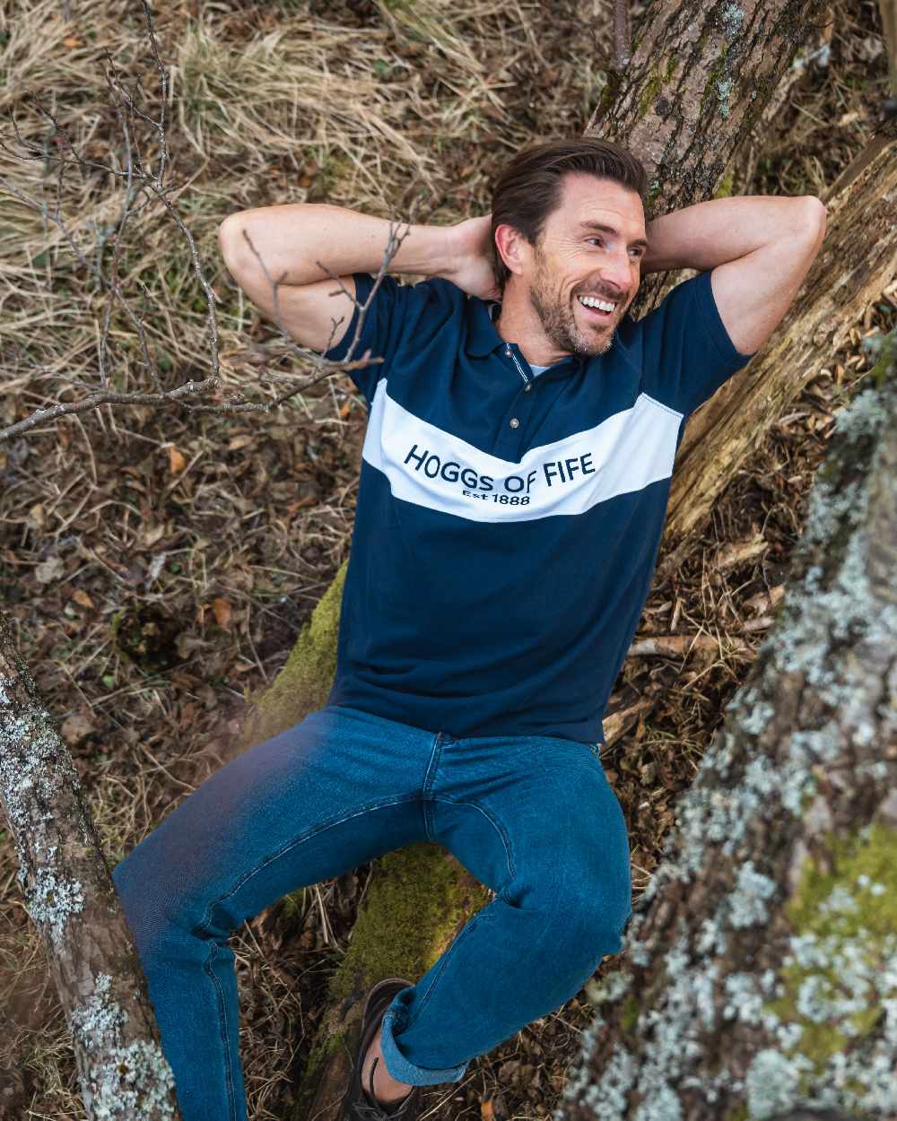 Navy Coloured Hoggs of Fife Mens Stewart Block Pique Polo Shirt on forest background