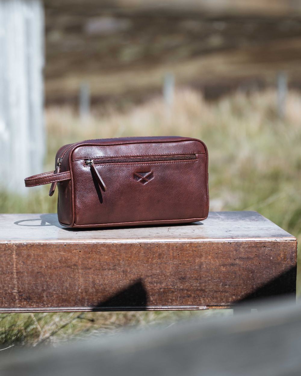 Conker Coloured Hoggs of Fife Monarch Leather Wash Bag on outdoor background