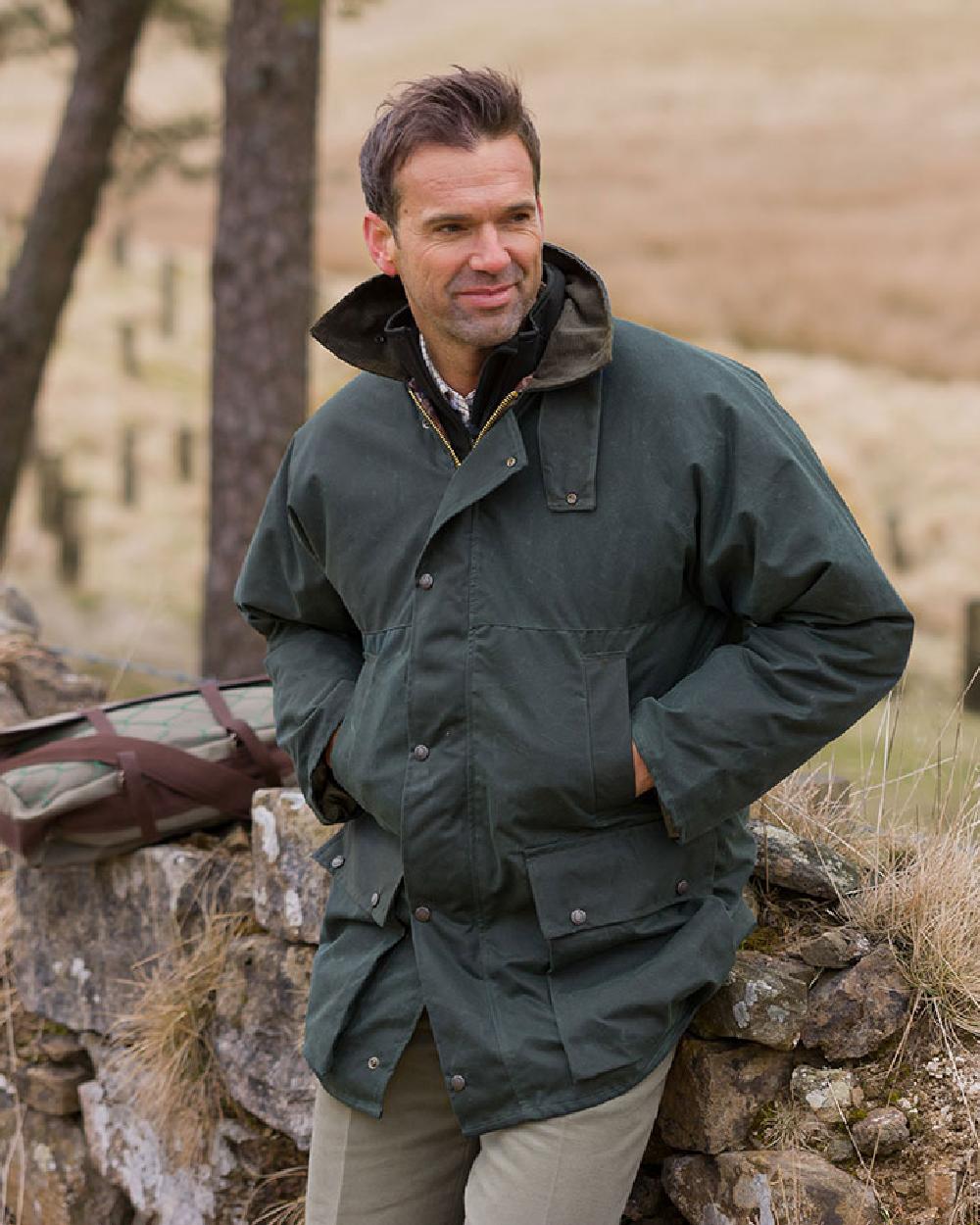 Olive Coloured Hoggs of Fife Padded Waxed Jacket on countryside background