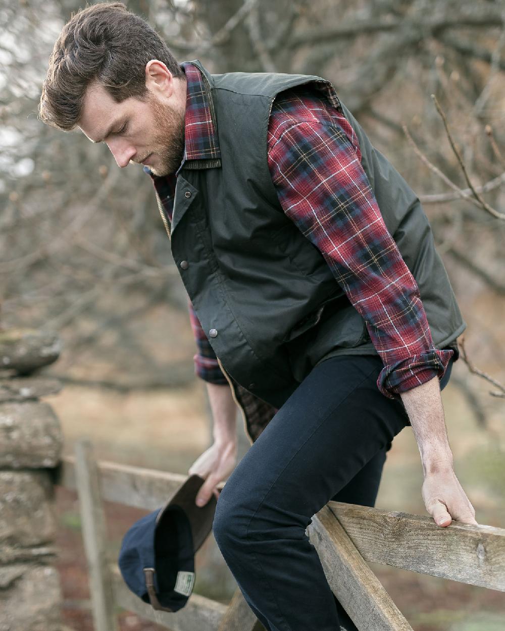 Olive Coloured Hoggs of Fife Waxed Waistcoat on countryside background