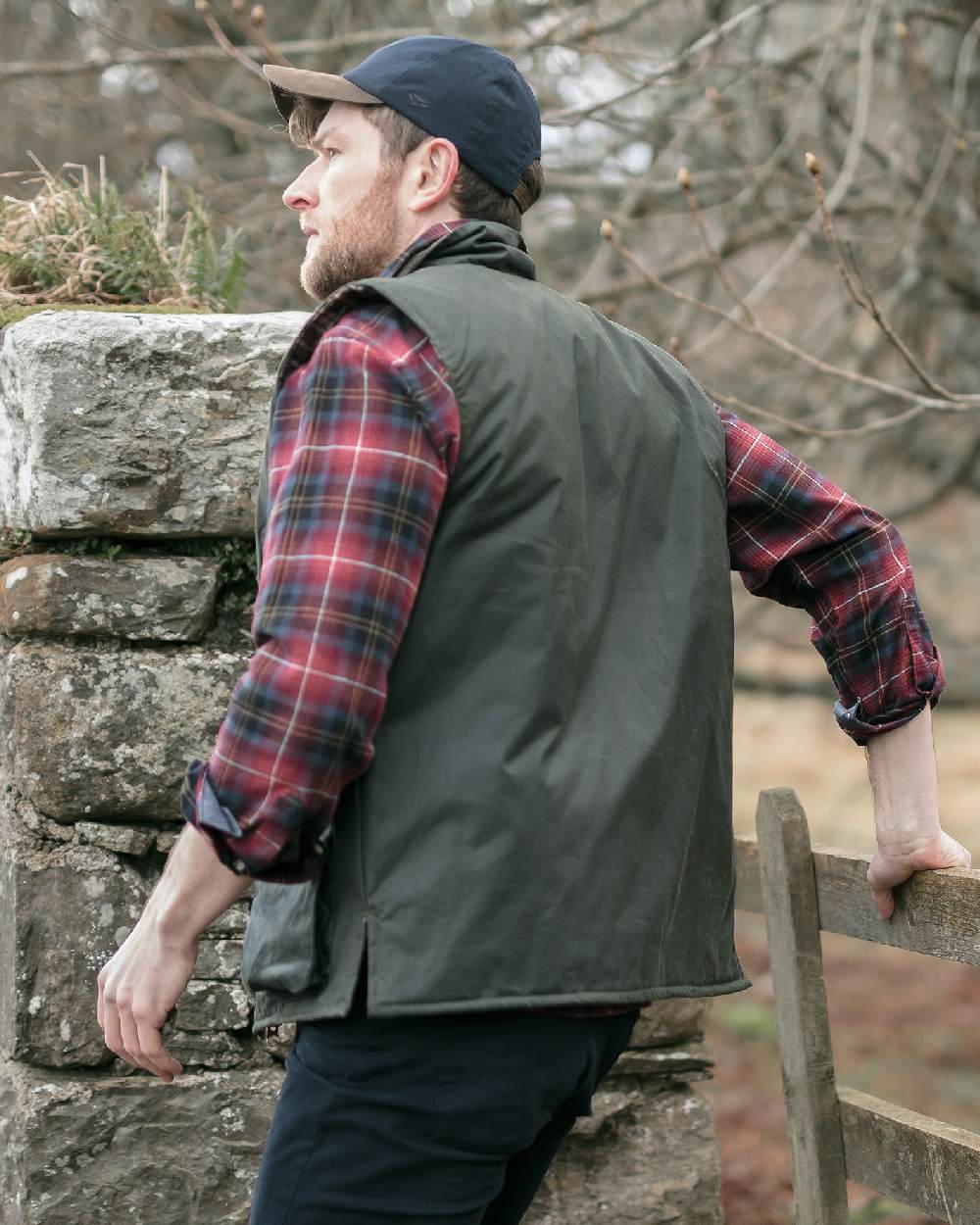 Olive Coloured Hoggs of Fife Waxed Waistcoat on countryside background
