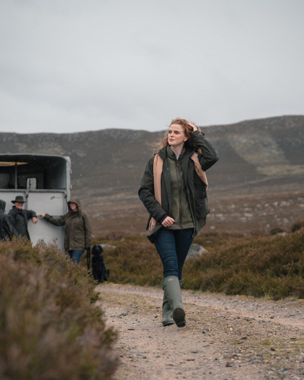 Dark Olive coloured Hoggs of Fife Womens Ardross Pro Waterproof Field Jacket on moorland background