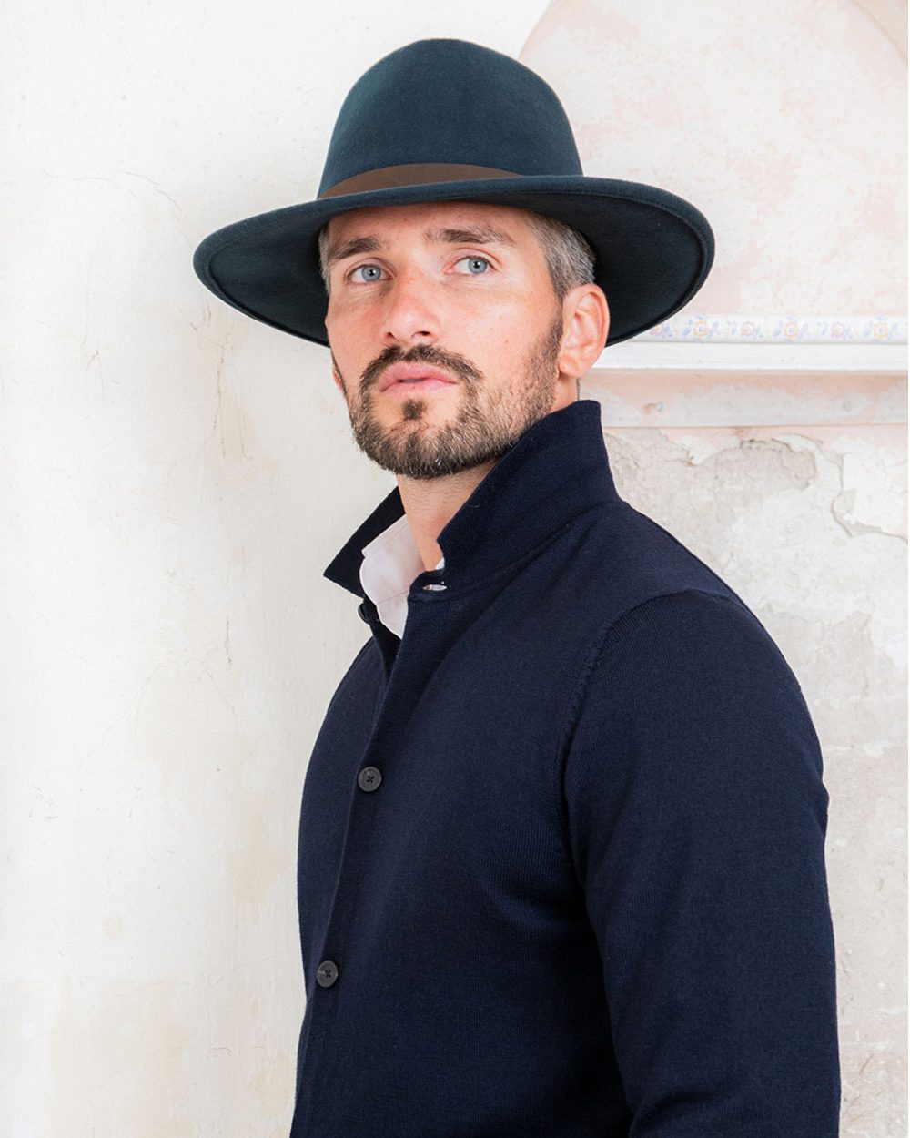 Navy coloured Jack Murphy Boston Crushable Felt Hat on wall background