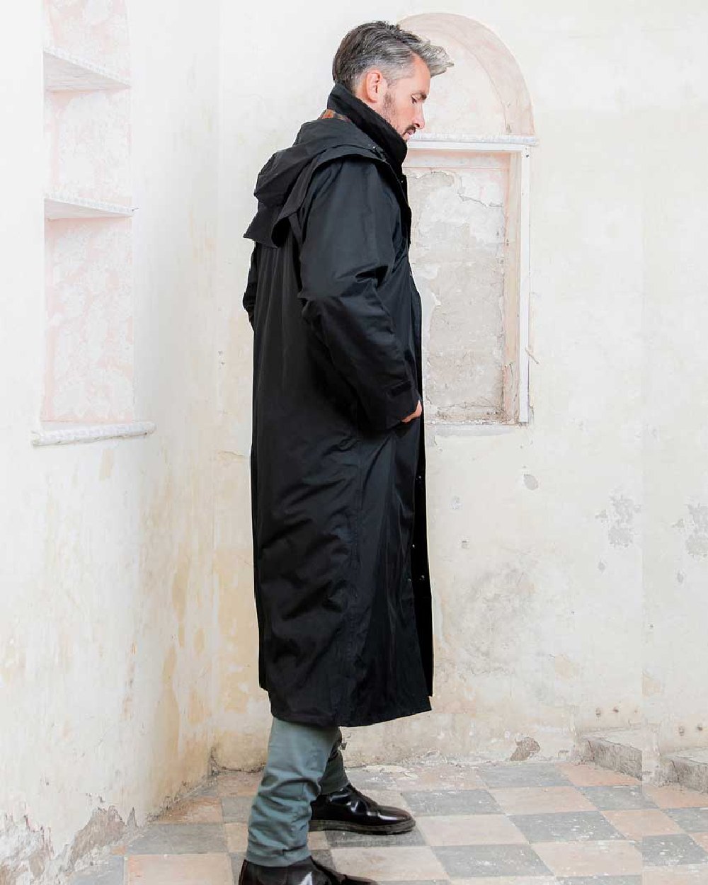 Black coloured Jack Murphy Lambourne Mens Long Bush Coat on wall background